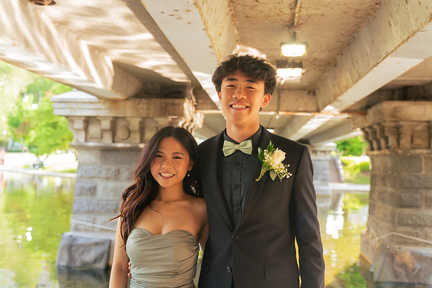 A prom couple pose under the bridge at Boston Public Garden