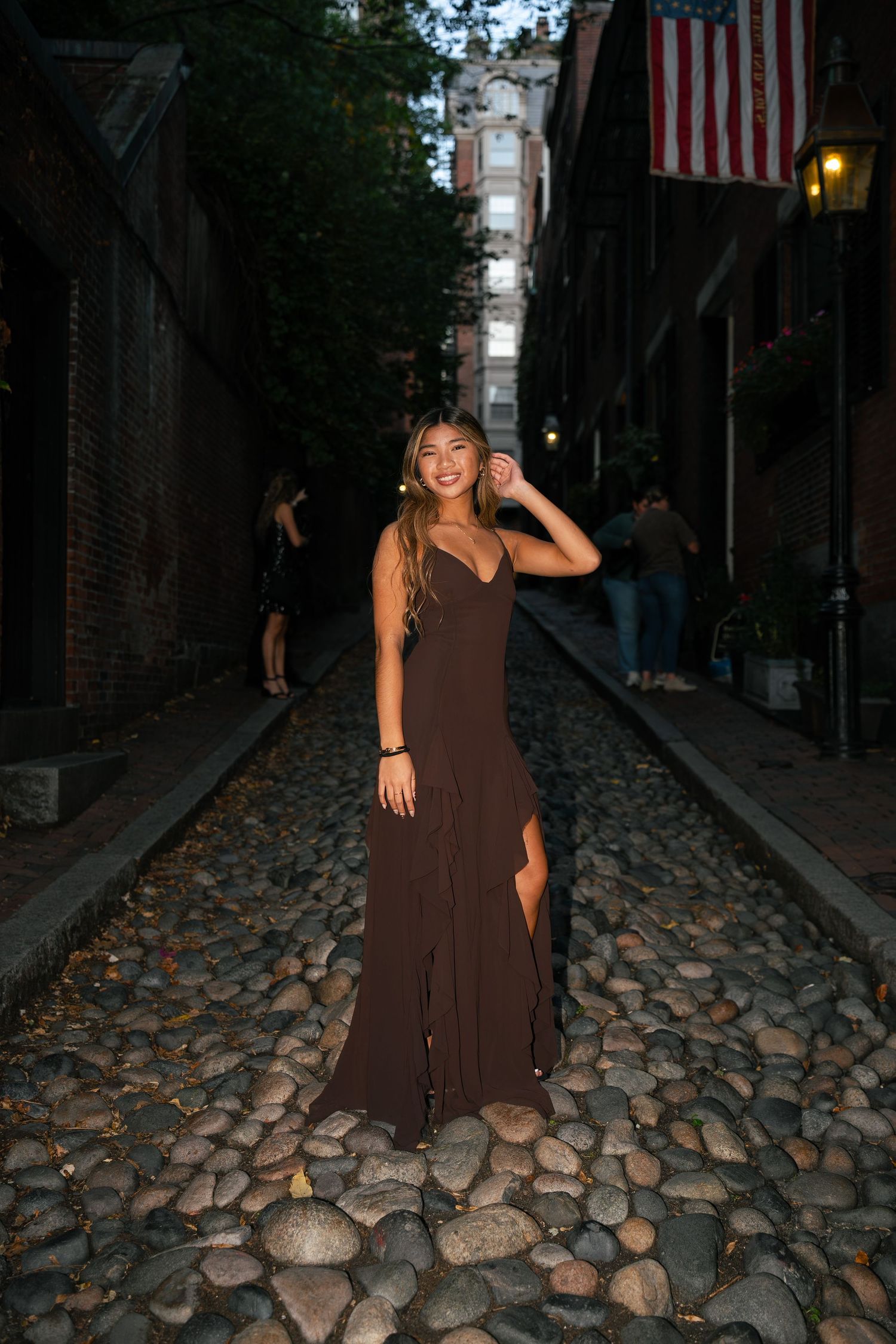 A girl poses to the right and faces front on Acorn Street.