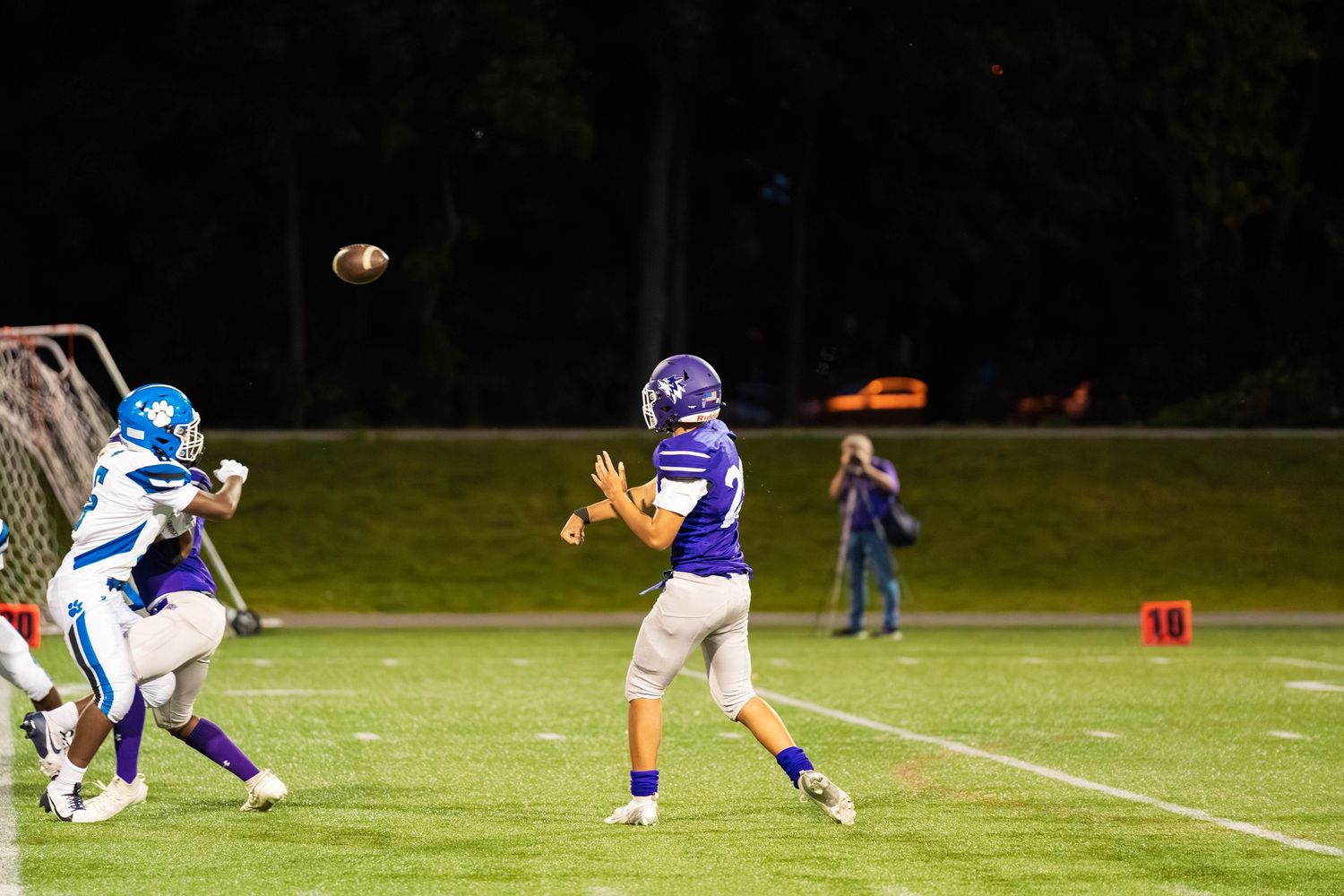 A quarter back throws the football at teammate