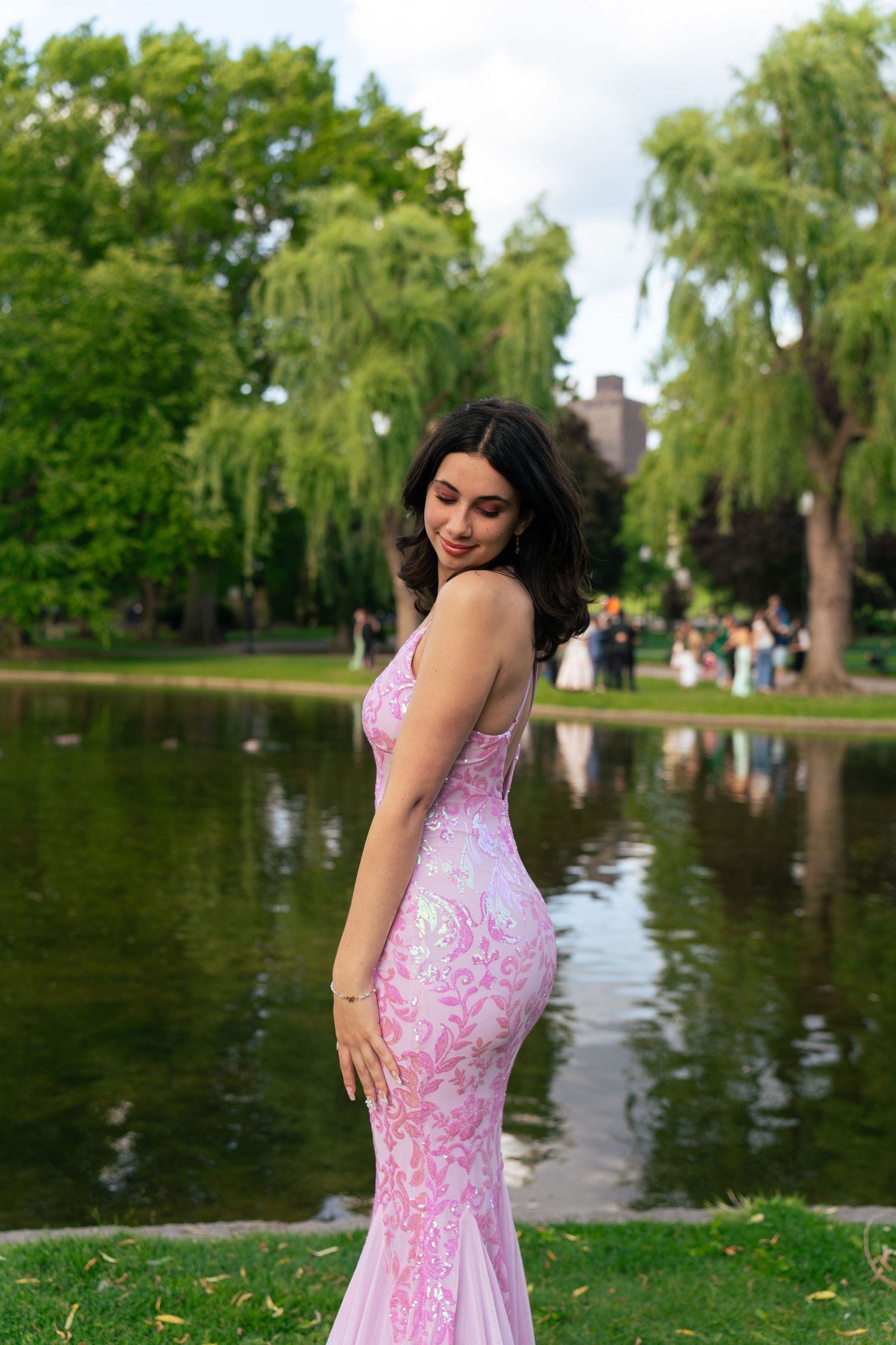 A girl poses in her pink prom dress.
