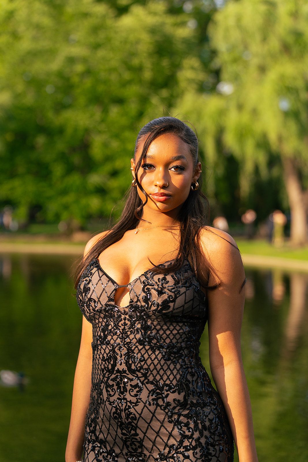 A girl poses in front of the Swan Pond at Boston Public Garden