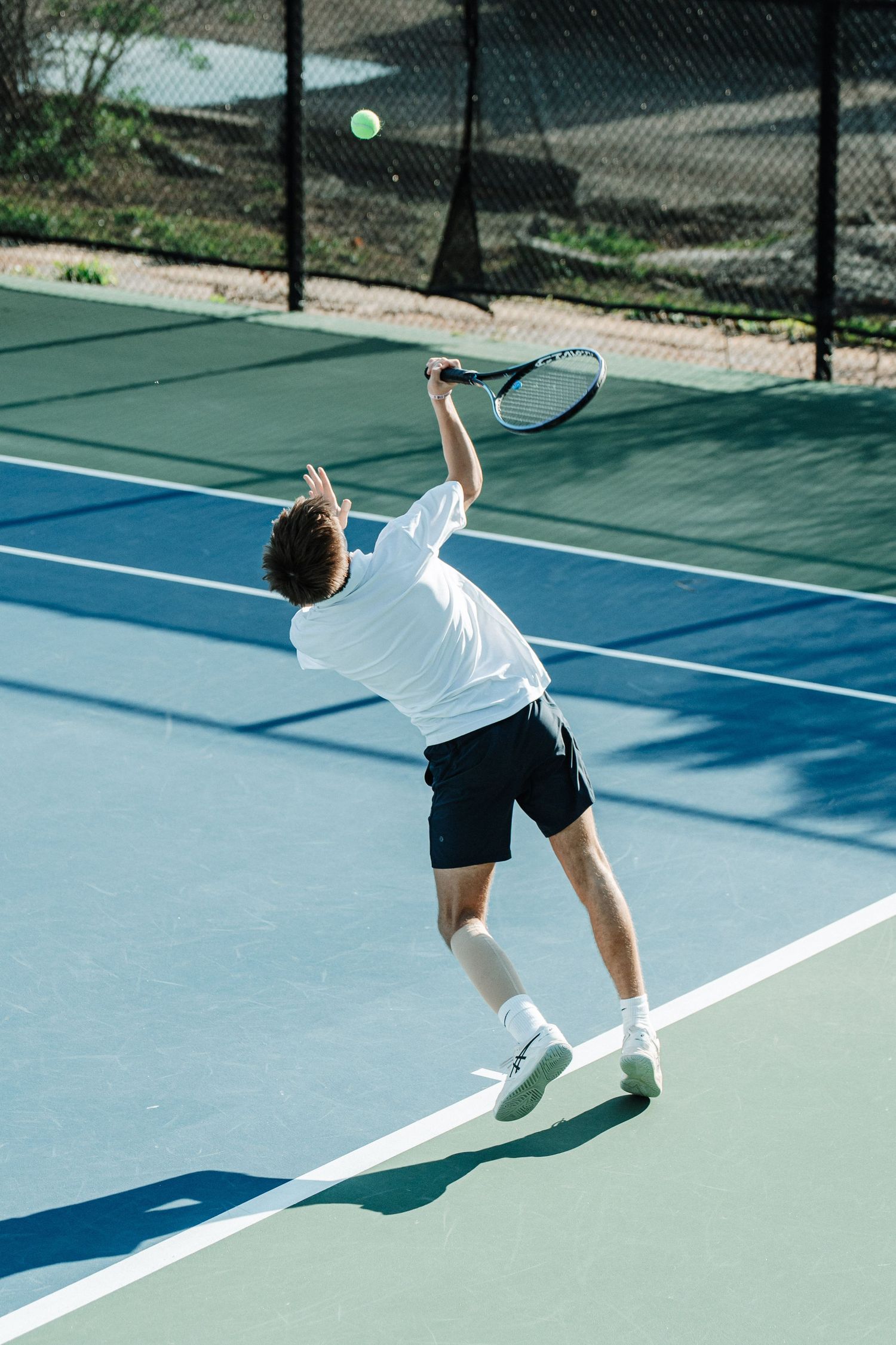 A tennis player returns a serve to his opponent