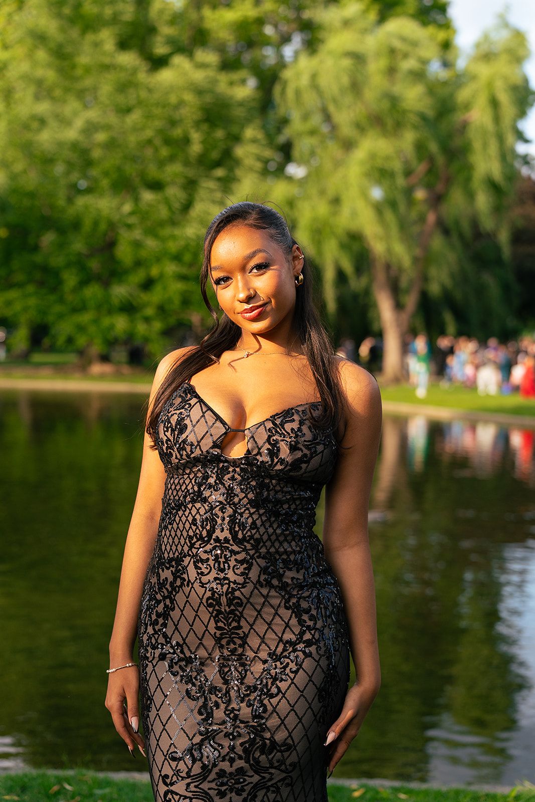 A girl poses in front of the Swan Pond at Boston Public Garden