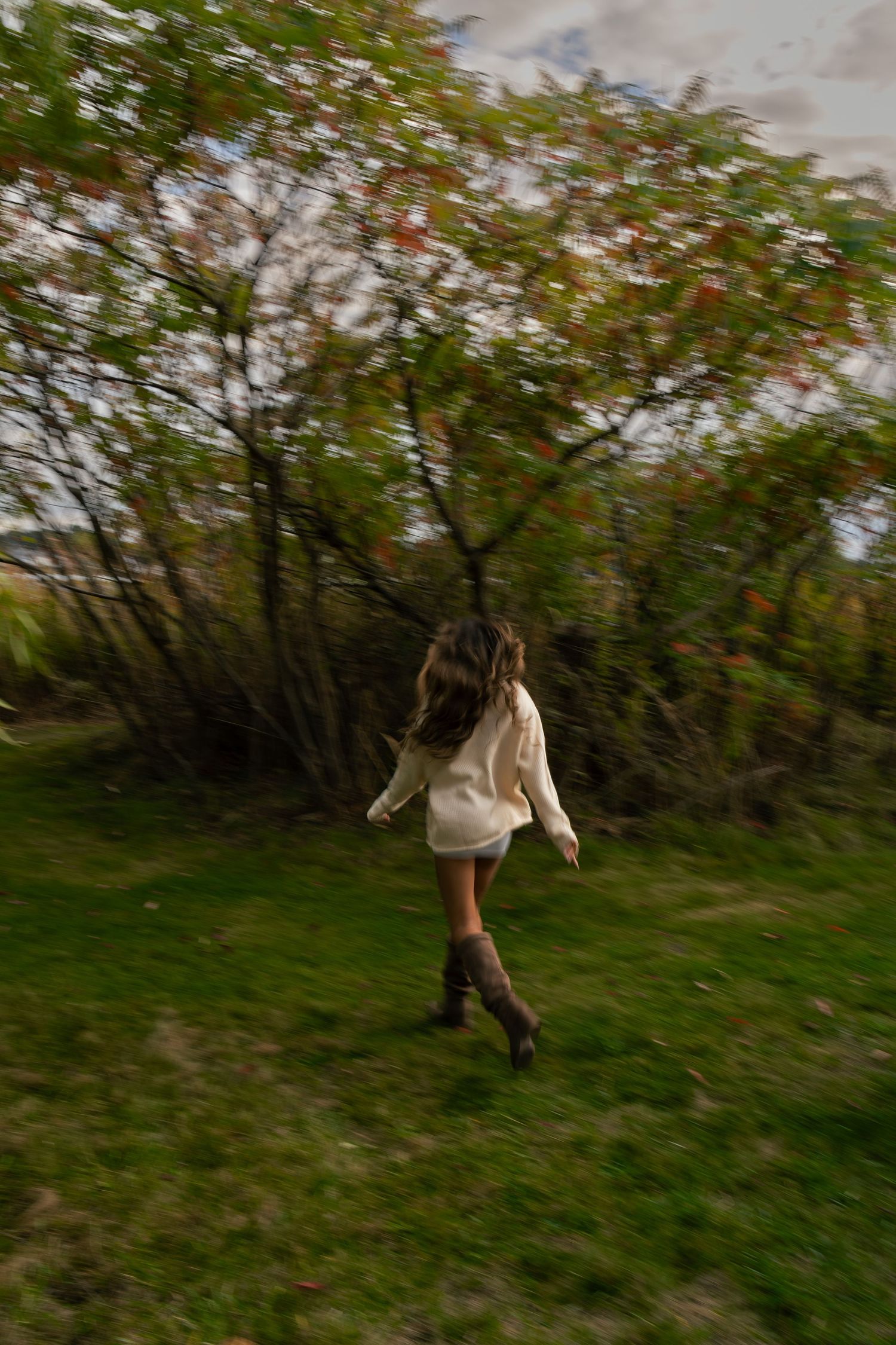 A girl prances through the woods.