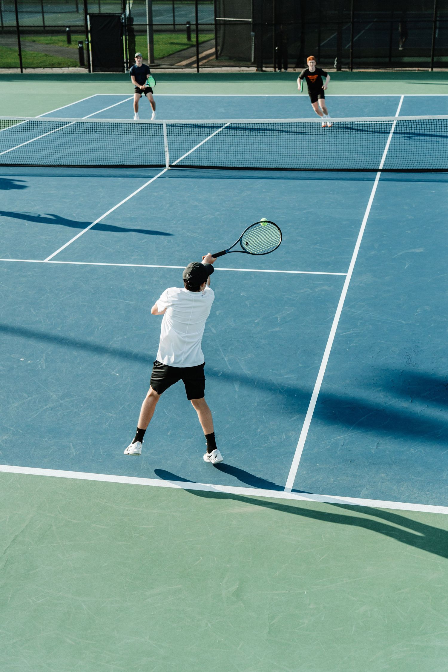 A tennis player returns a serve with an underhand hit.
