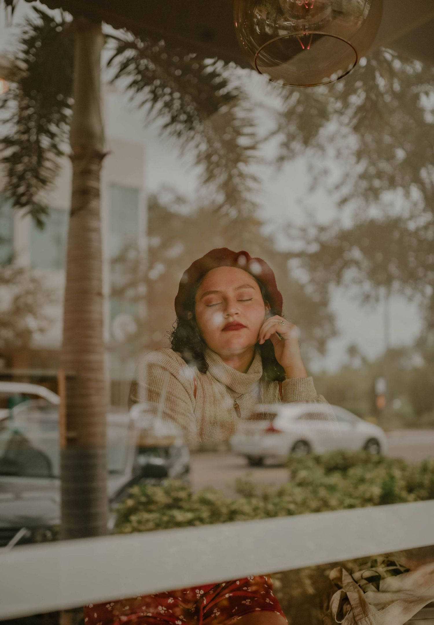 Dreamy outdoor portrait with palm trees and bokeh lighting effects.
