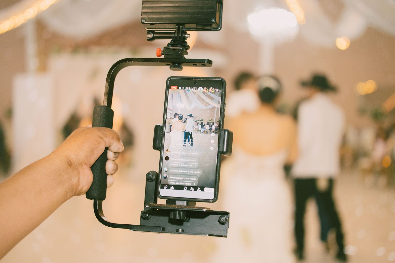 Smartphone in a stabilizer rig filming a wedding couple dancing at a reception venue.