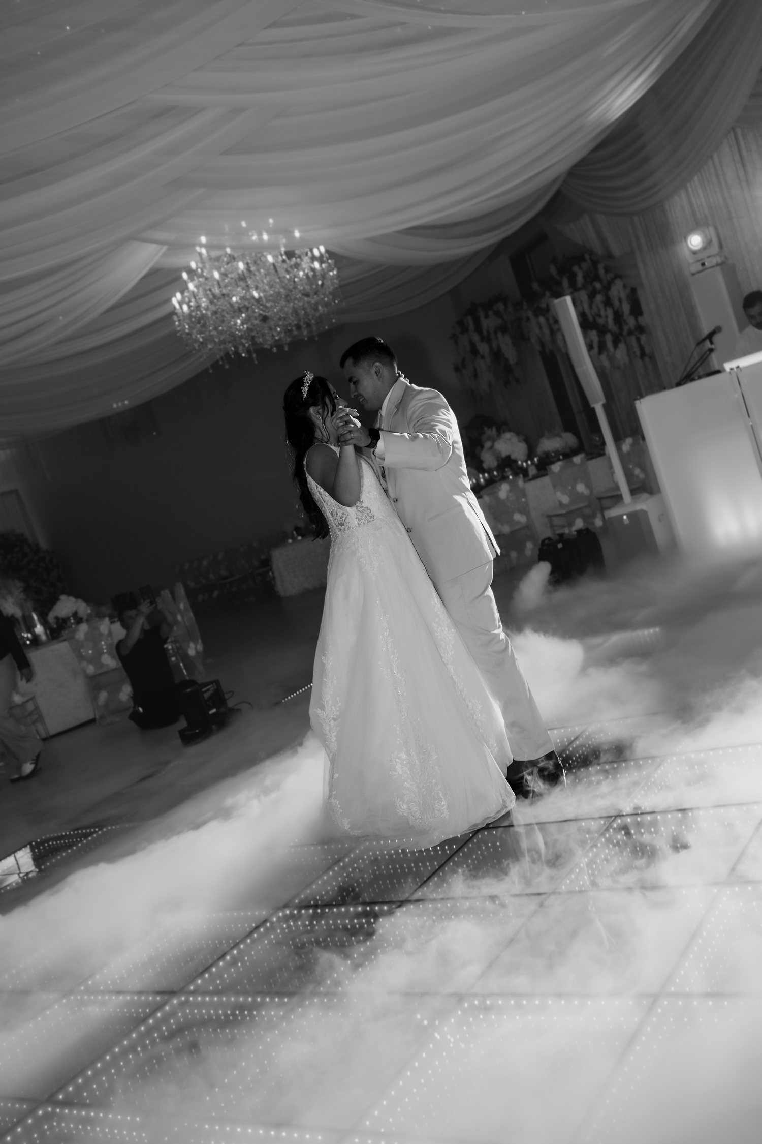 Black and white romantic first dance photo of bride and groom surrounded by fog.