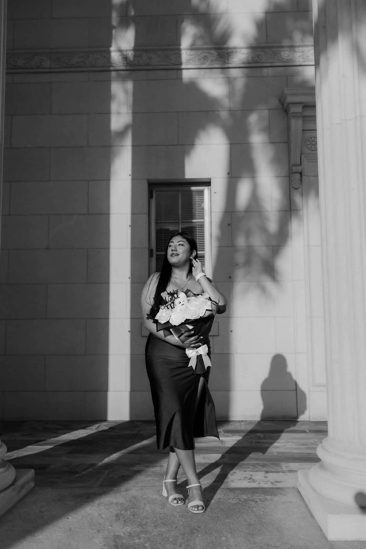 A sequence of black and white photos showing a figure dancing and moving between architectural columns with dramatic shadows.