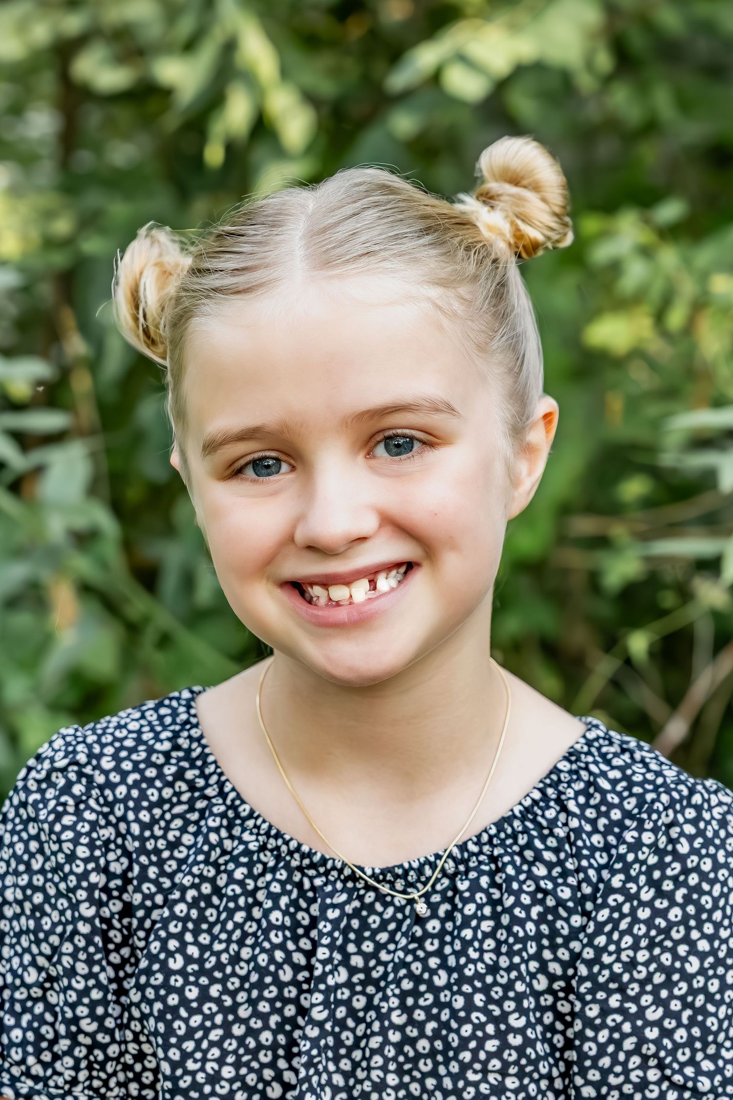 A series of four photos showing a child in a floral dress expressing different playful emotions and expressions outdoors.