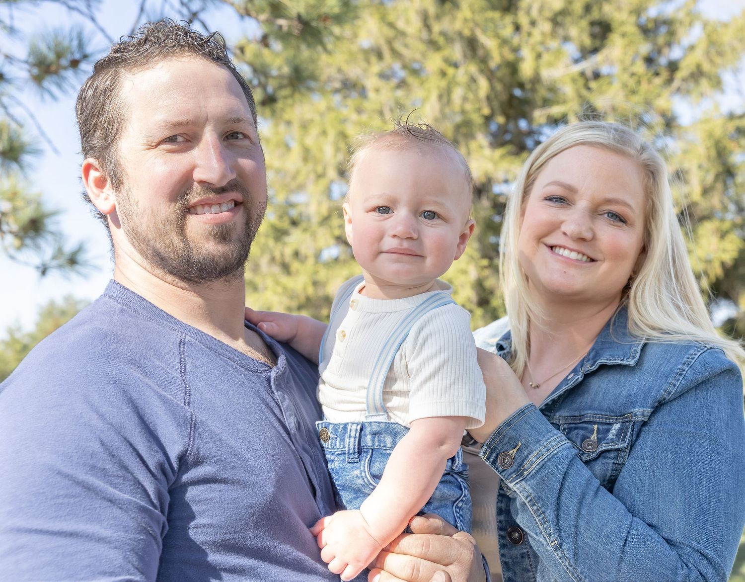 Family portrait series captured in warm sunlight with pine trees in the background.