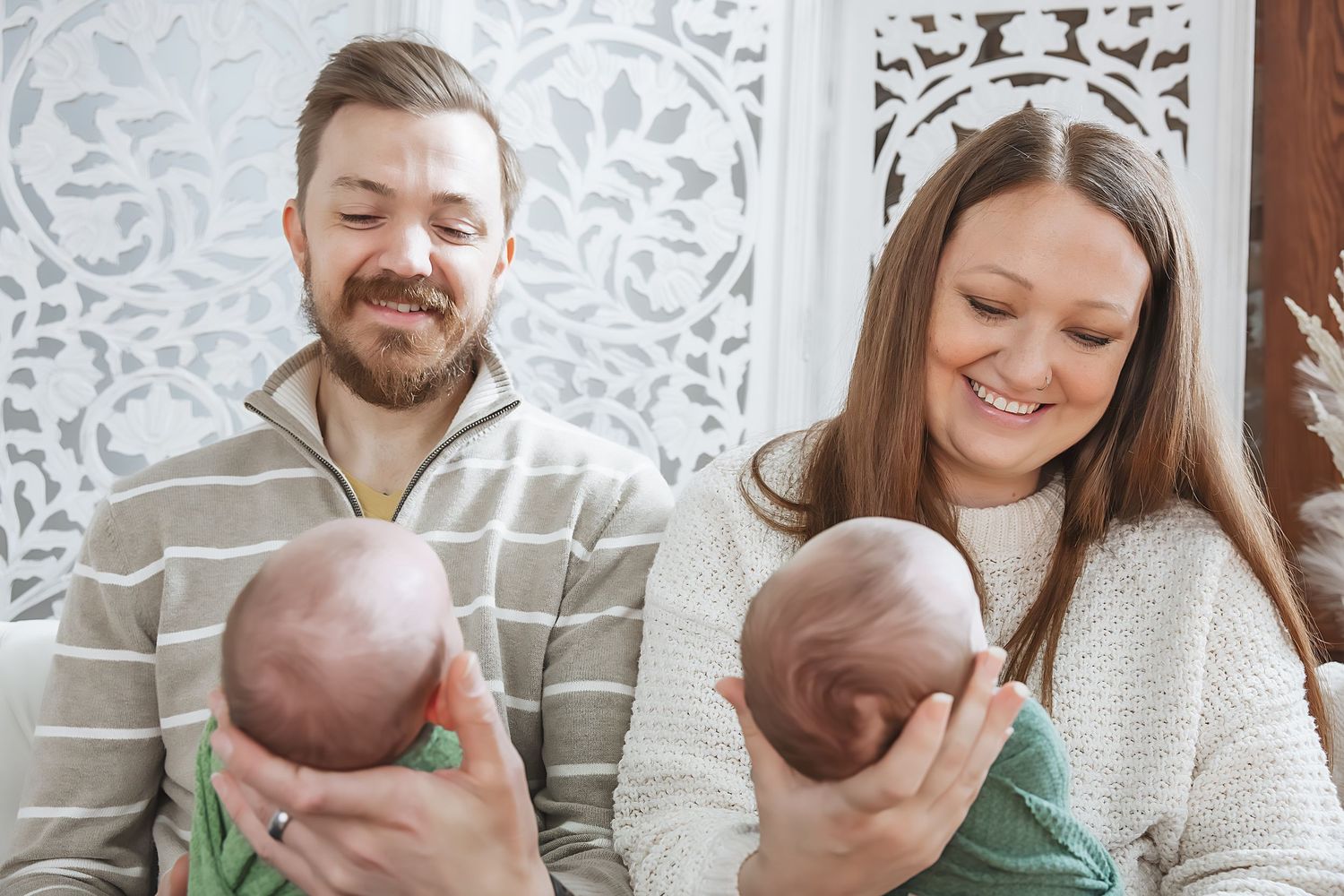 A family sits together on a couch sharing tender moments with their baby in a series of candid photos.