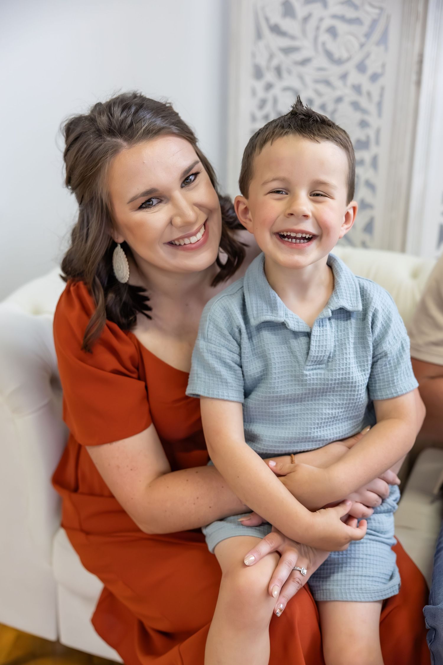 Mother and child sharing joyful moments together on white couch.