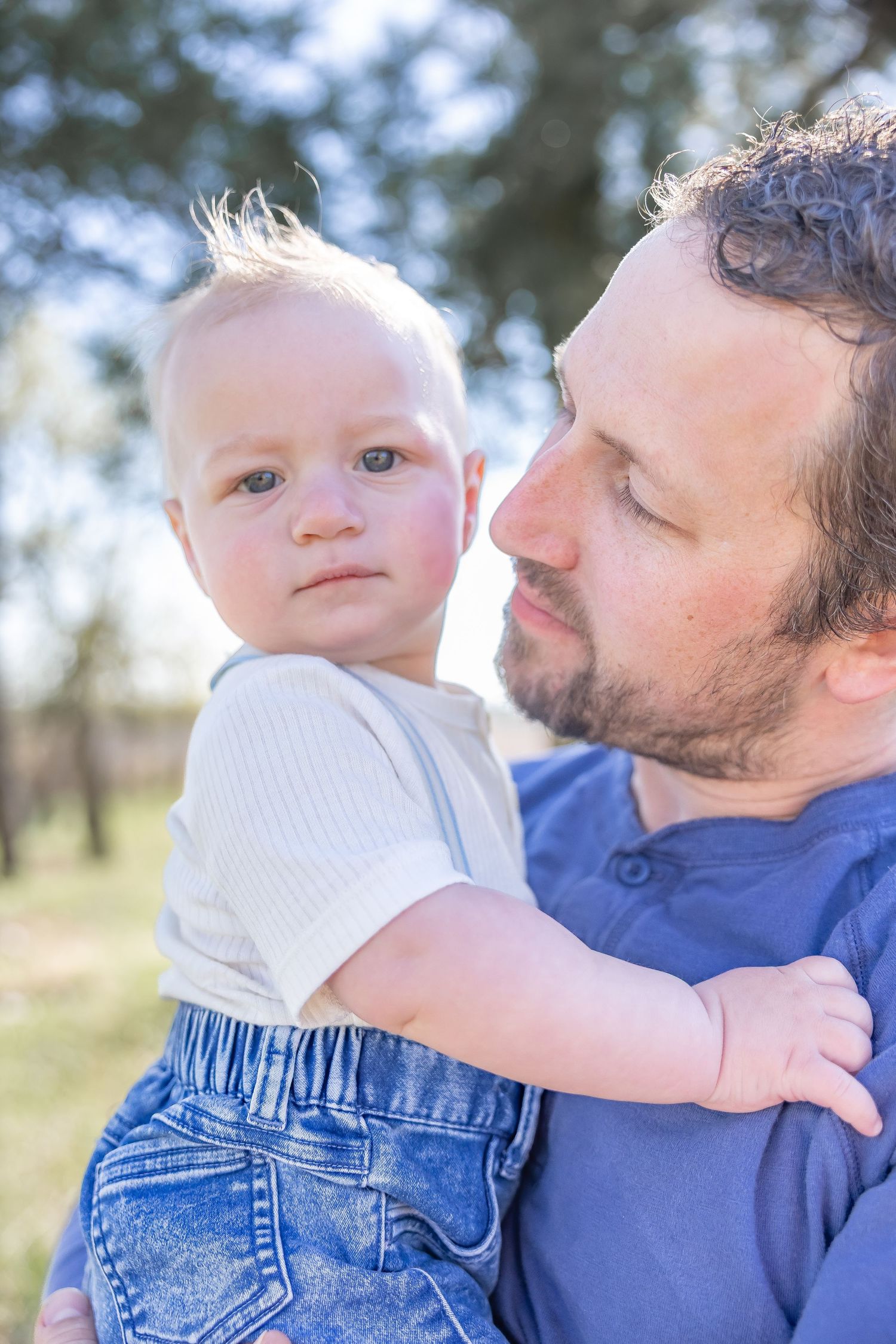 Intimate parent-child moments captured in series of outdoor portraits with blue clothing.