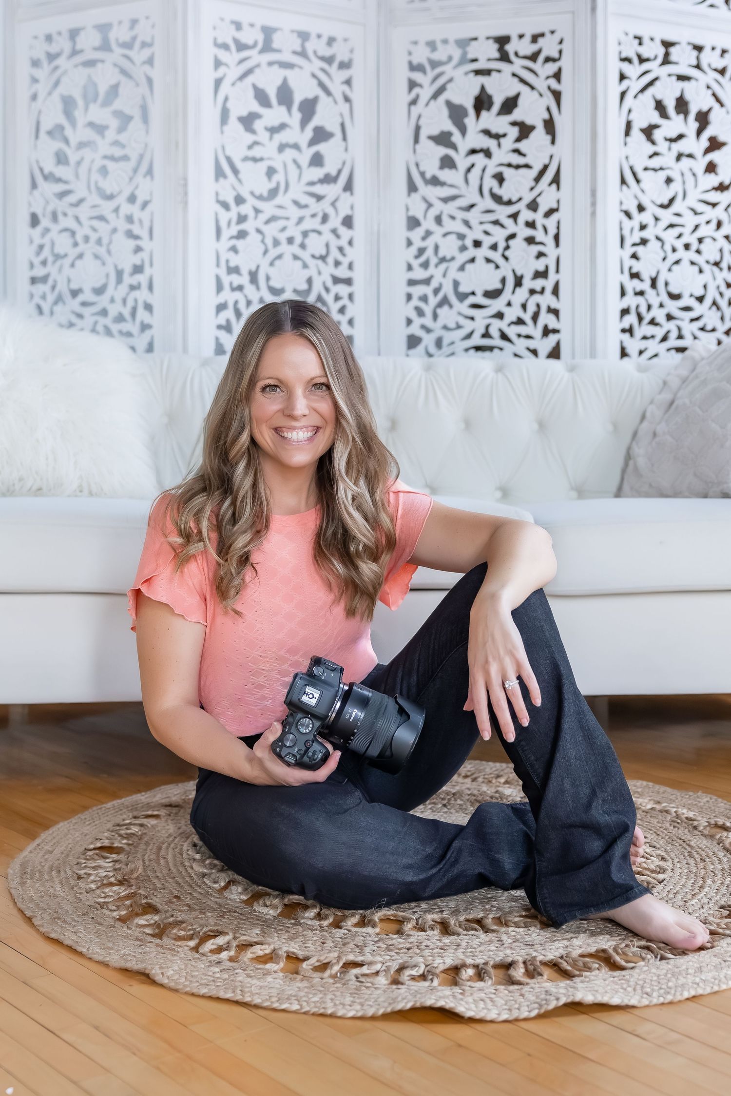 Professional photographer relaxing with camera on decorative round rug.