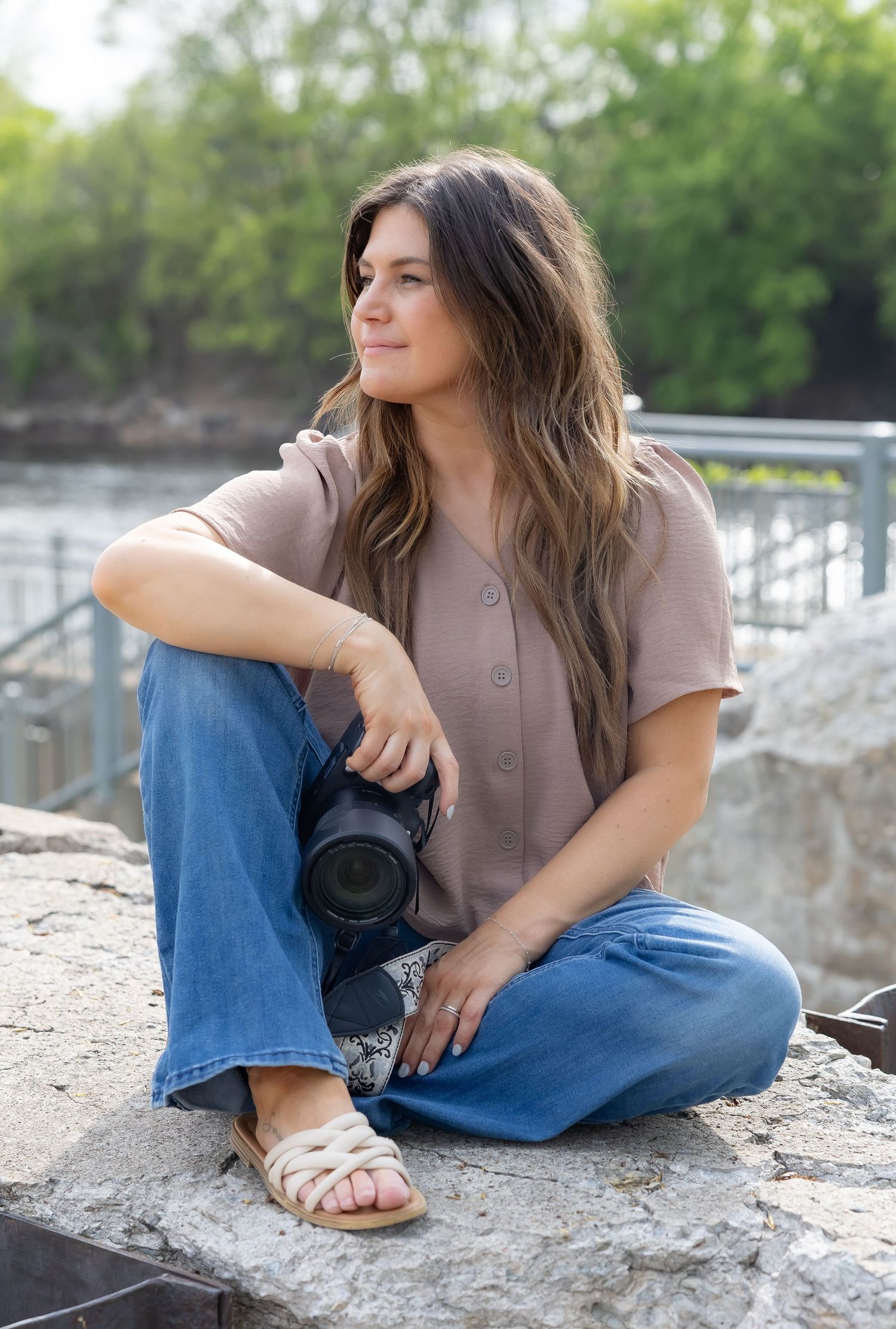 Casual photography session with someone in jeans sitting on concrete structures outdoors.
