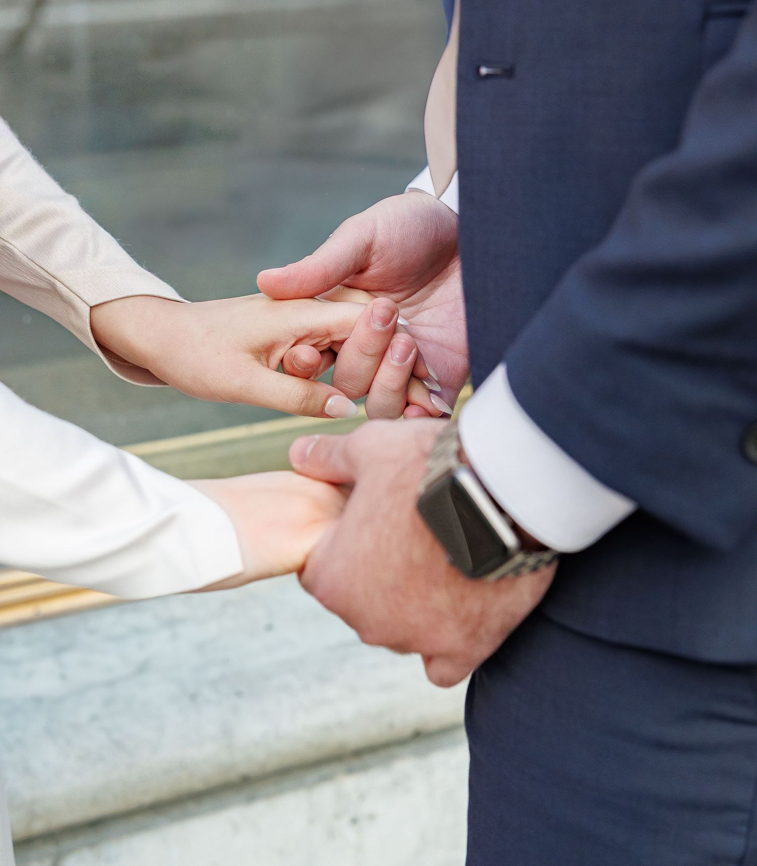 Close-up shots of hands during a wedding ceremony exchange.