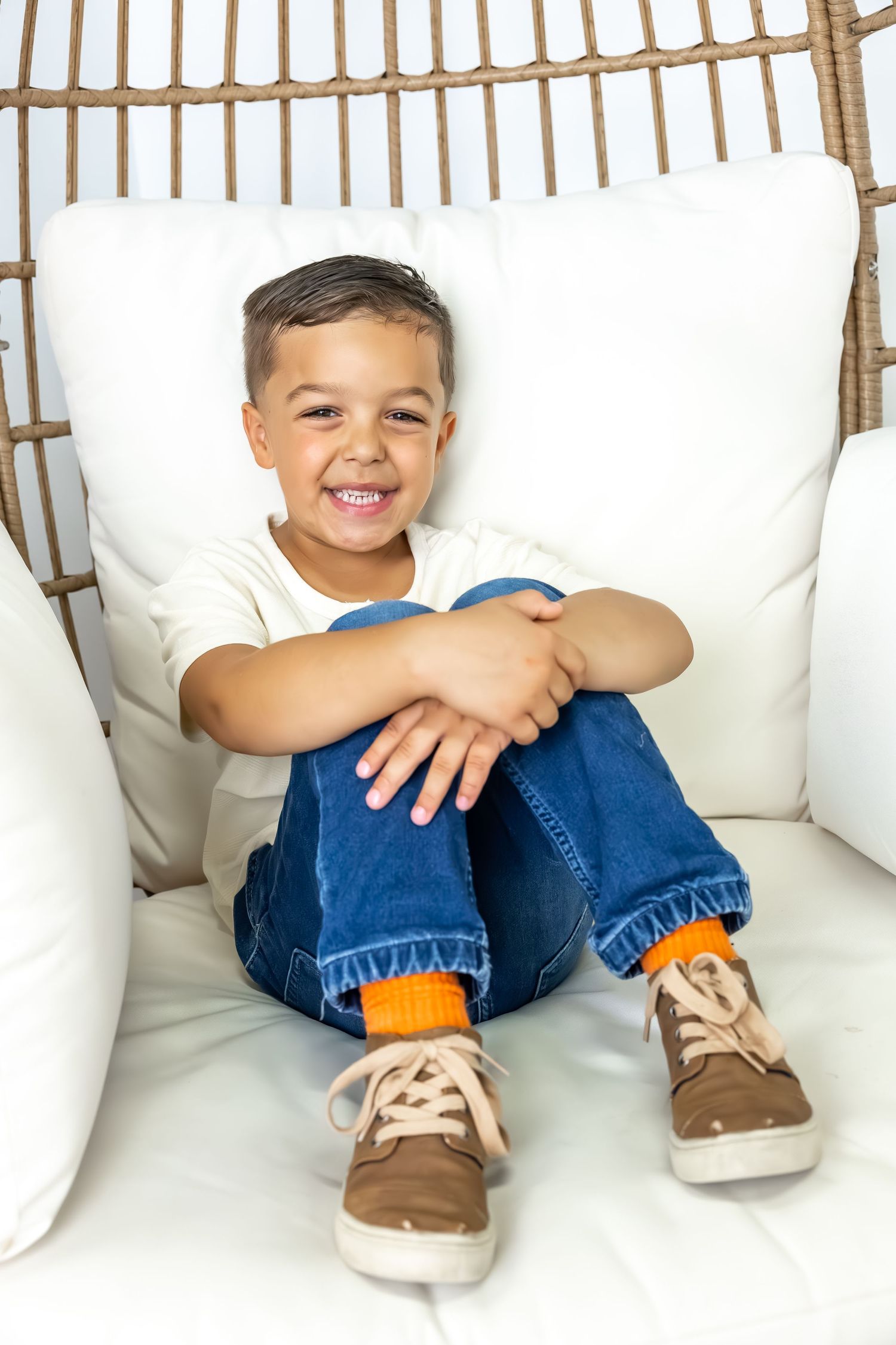 Blue jeans and brown shoes visible through wooden slats against white cushions.