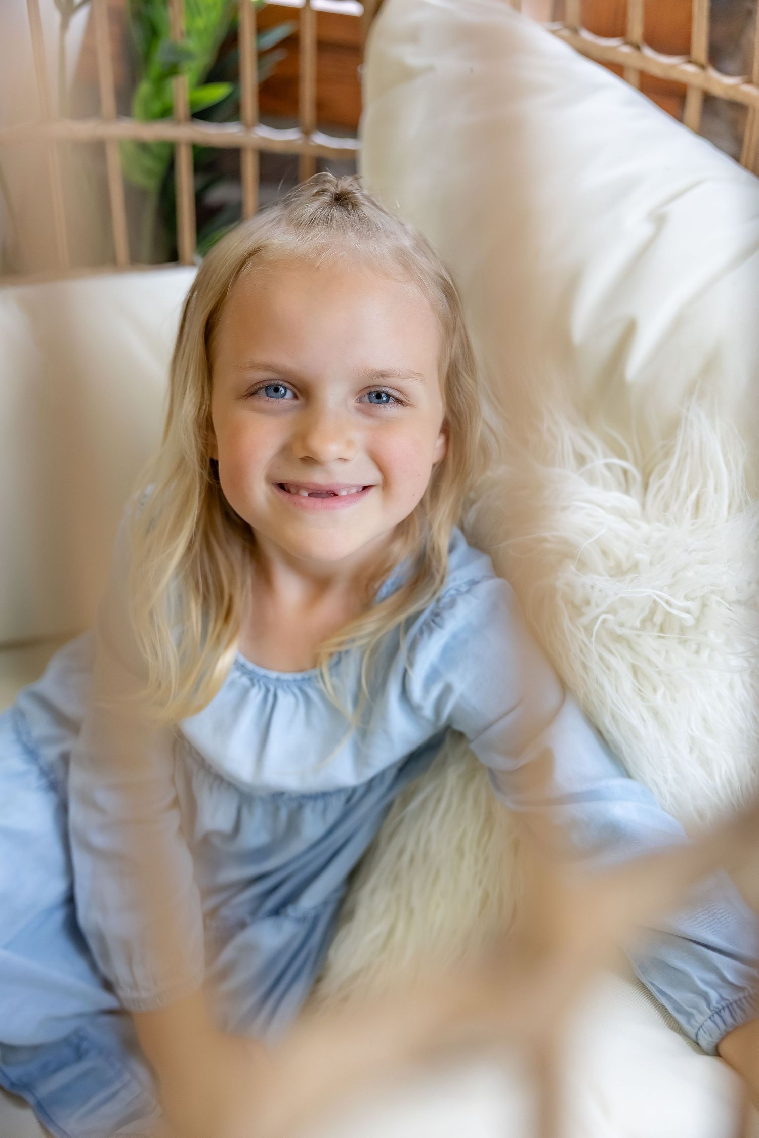 Portrait through soft focus showing light blue dress and gentle expression.