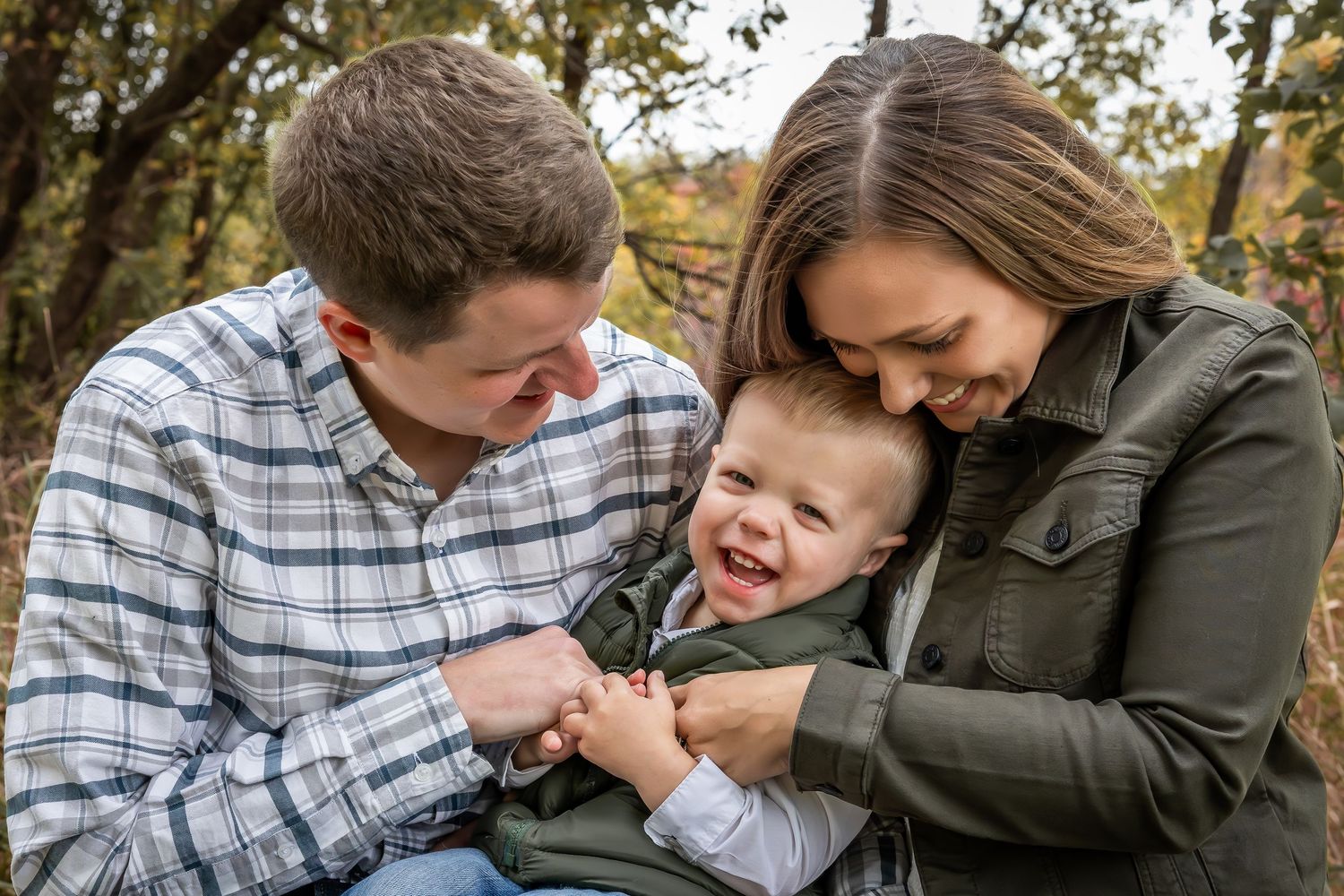 Candid family moment showing playful interaction outdoors in fall setting.