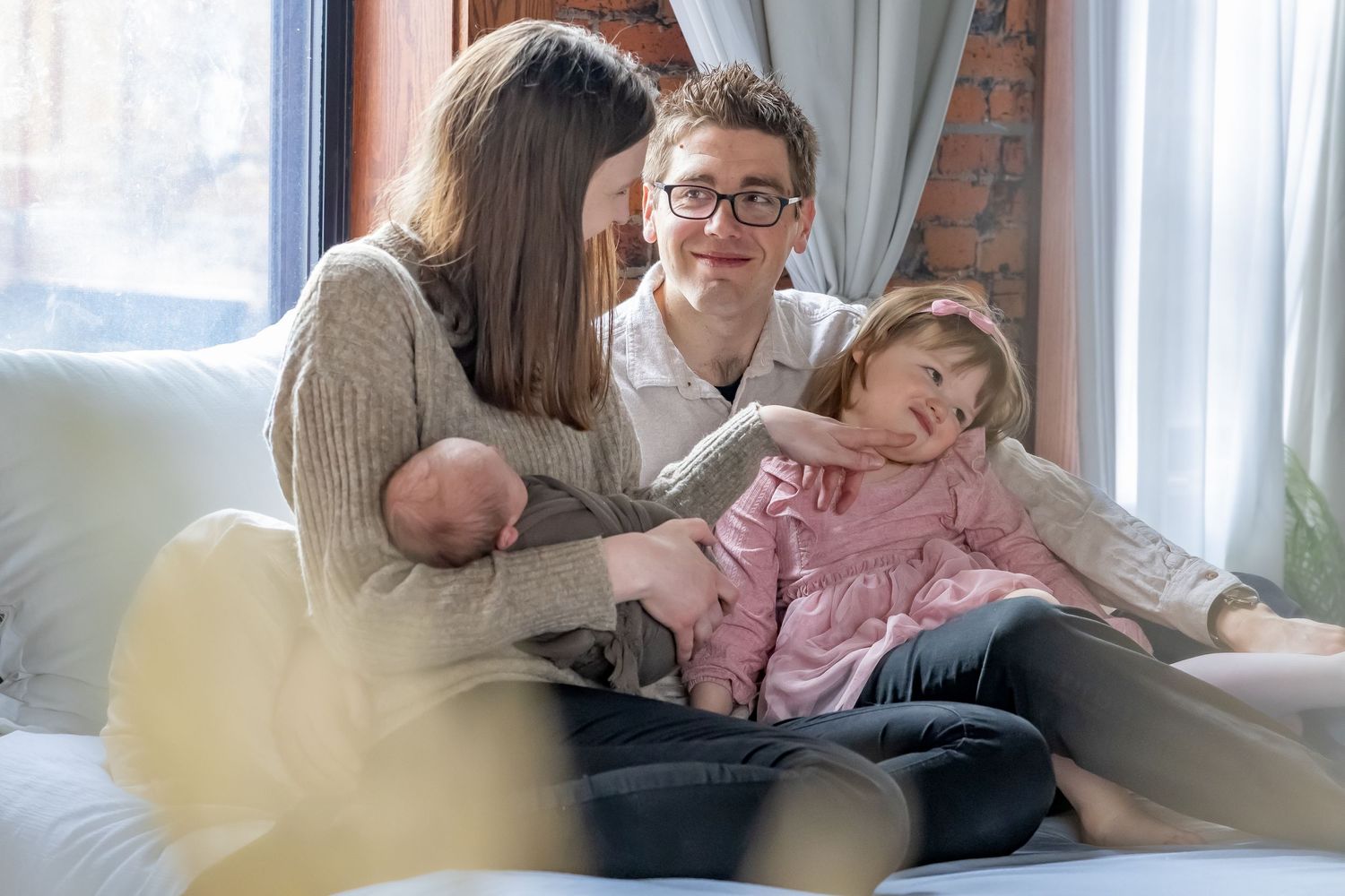 Indoor family lifestyle session with natural window light and comfortable home setting.