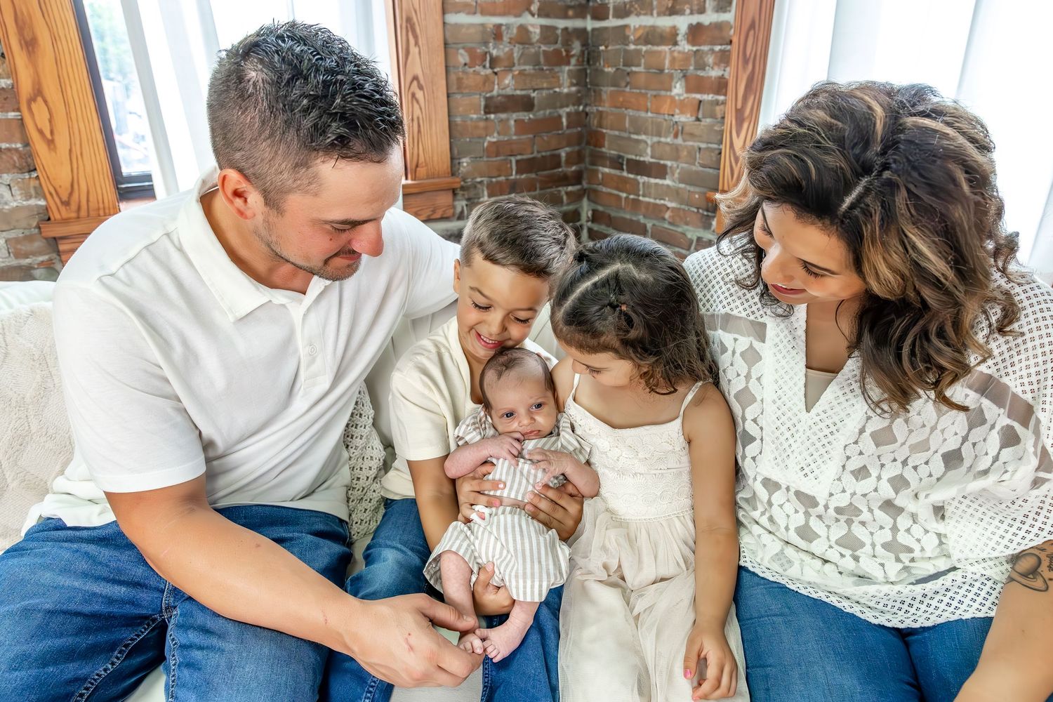 A family shares joyful moments together on a white couch.