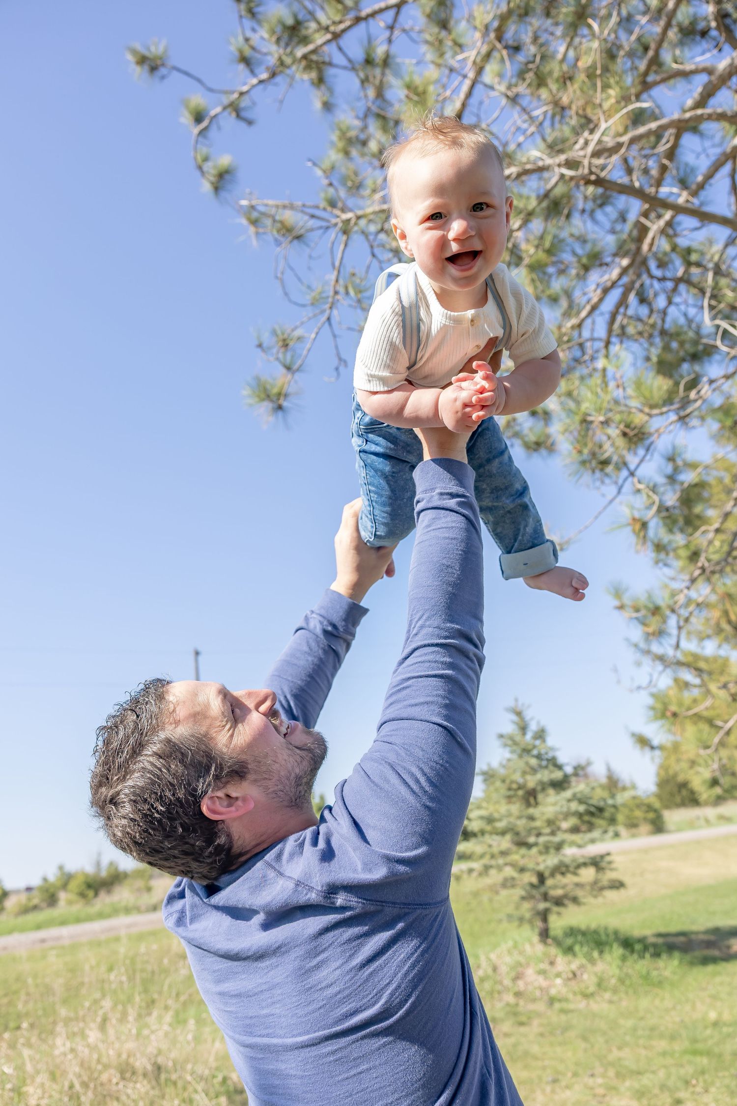 Playful sequence of lifting and spinning in the air against a bright blue sky.