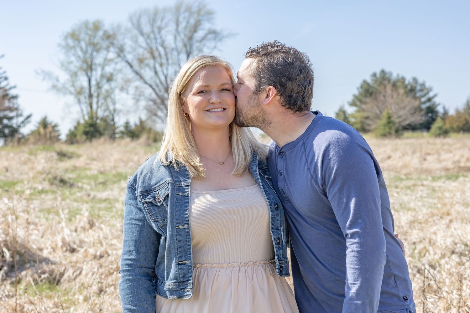 Romantic outdoor couple portrait session in casual attire against natural landscape.