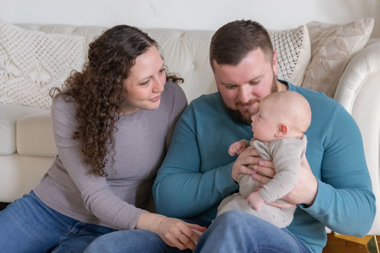 Cozy indoor family lifestyle photo session showing intimate moments on a white couch.