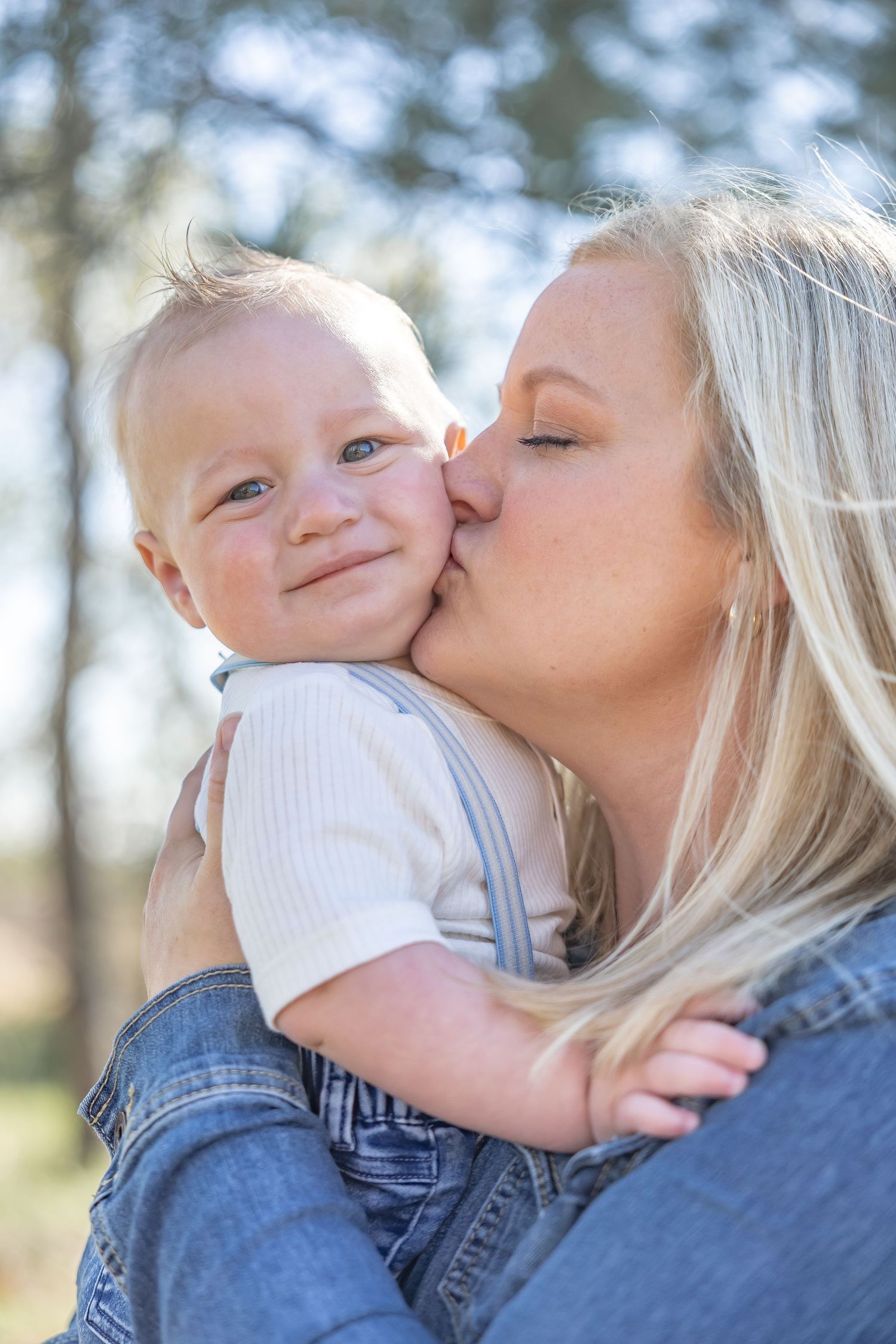 Loving exchanges between parent and baby shown in sequence of outdoor photos.