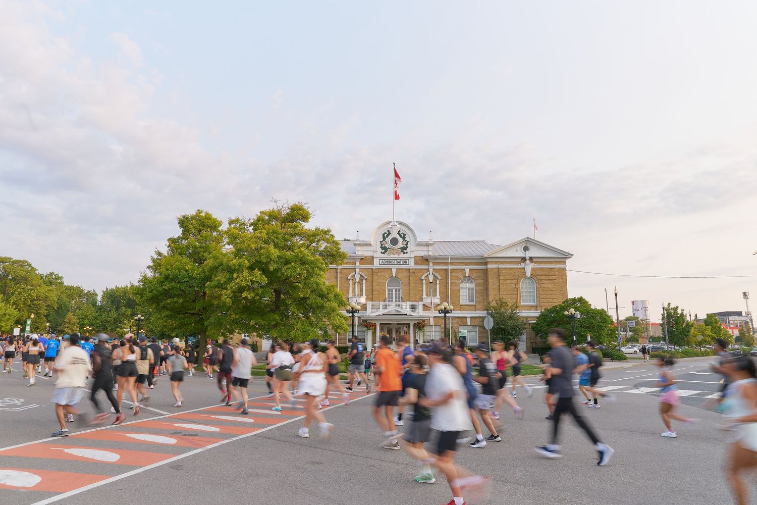 A diverse group of people running together on a city street during a marathon event.