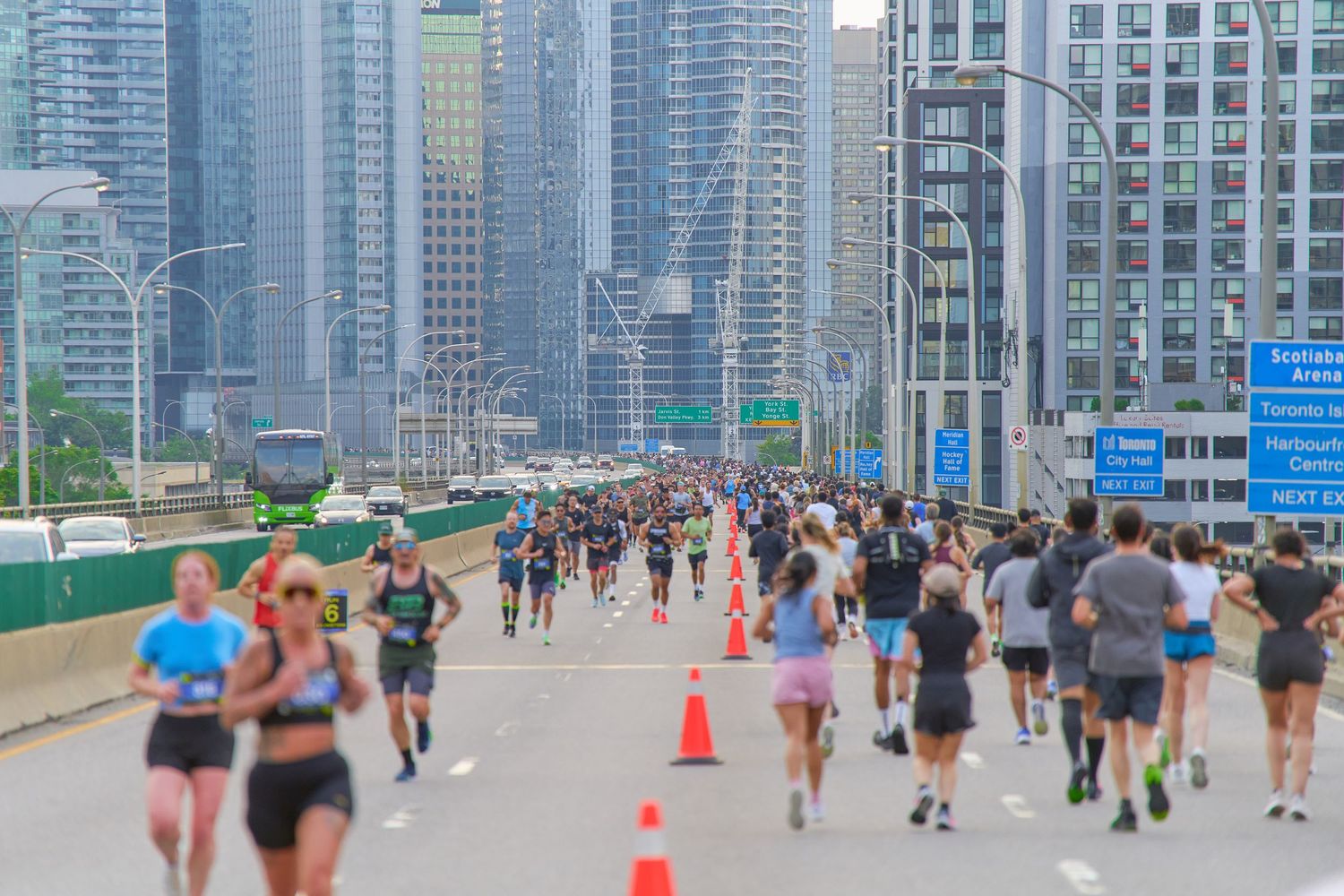 A diverse group of people running together on a city street during a marathon event.