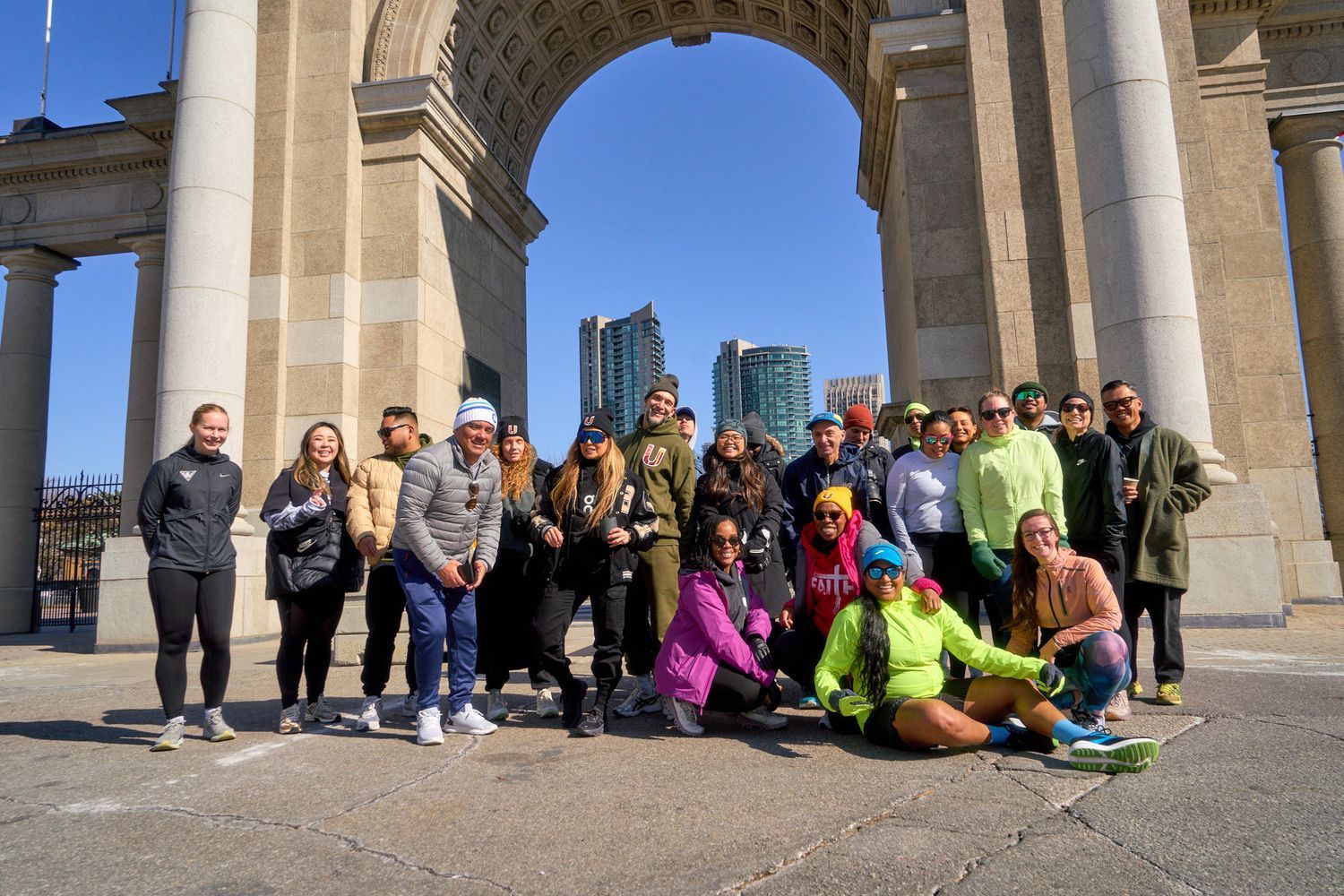 A group of smiling people poses together in front of a decorative arch, capturing a joyful moment.