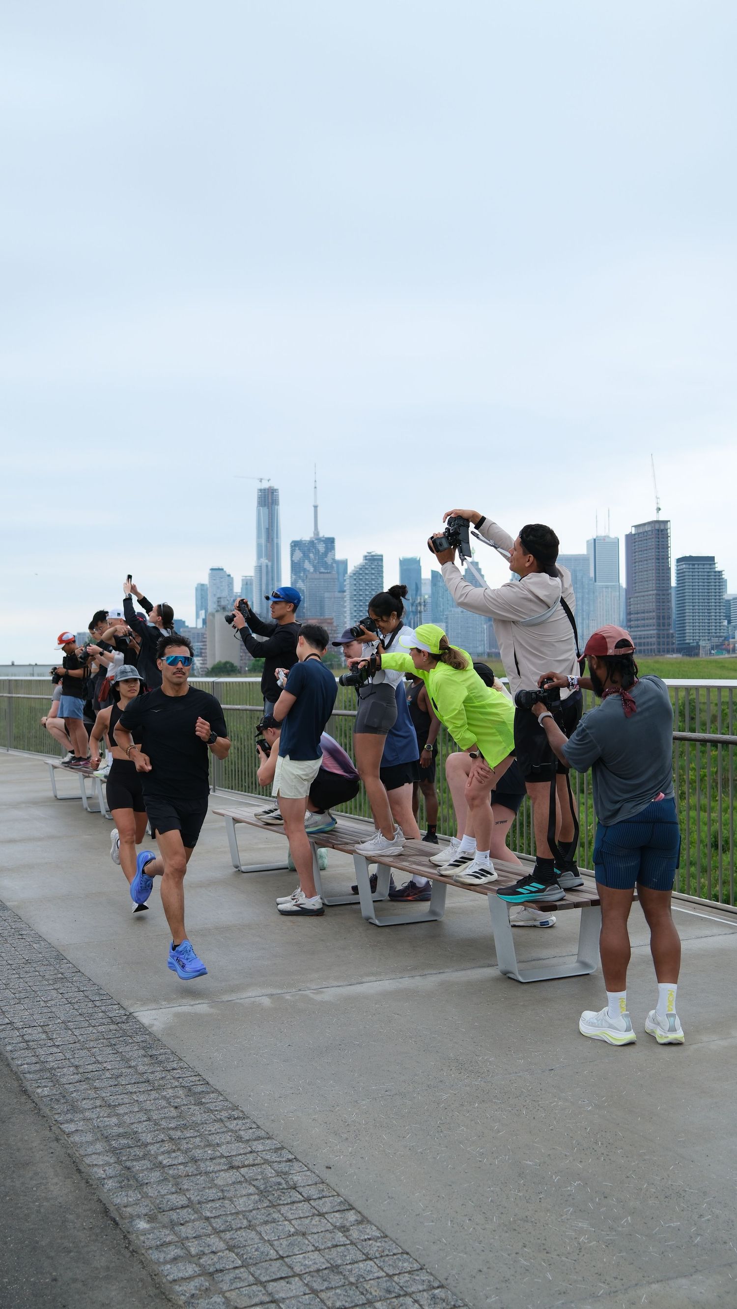 A group of people stands on a bench, with a city skyline visible in the background.