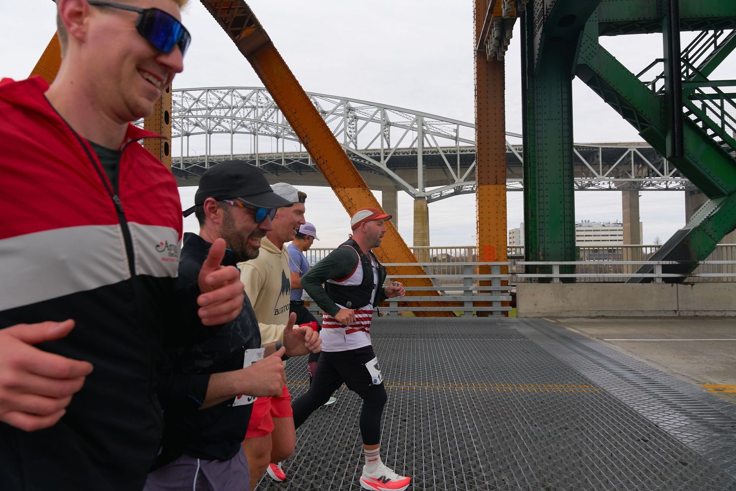 Runners sprinting under a bridge, highlighting their commitment to exercise in an outdoor space.