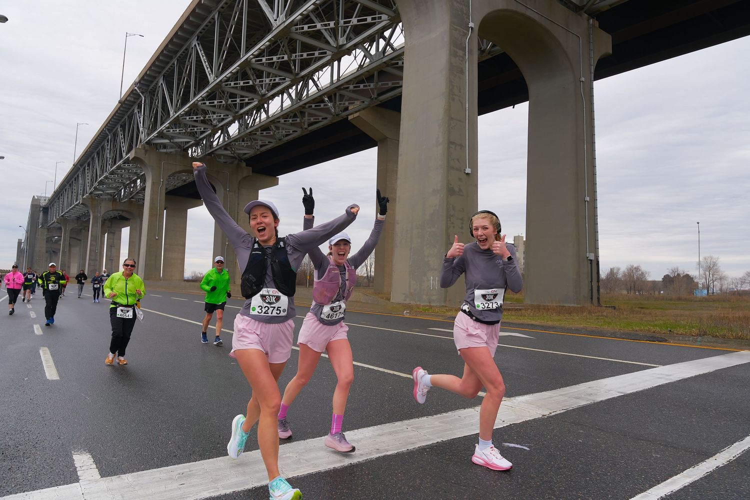 Women jogging beneath a bridge, emphasizing fitness and movement in a city setting.