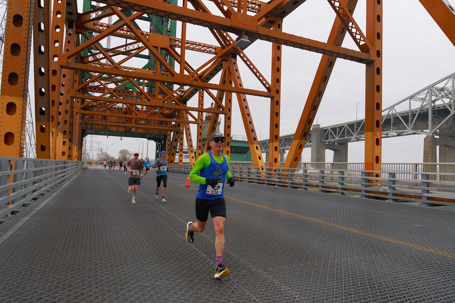 A man engaged in jogging beneath a bridge, highlighting their athletic attire and resolve as they partake in outdoor exercise.