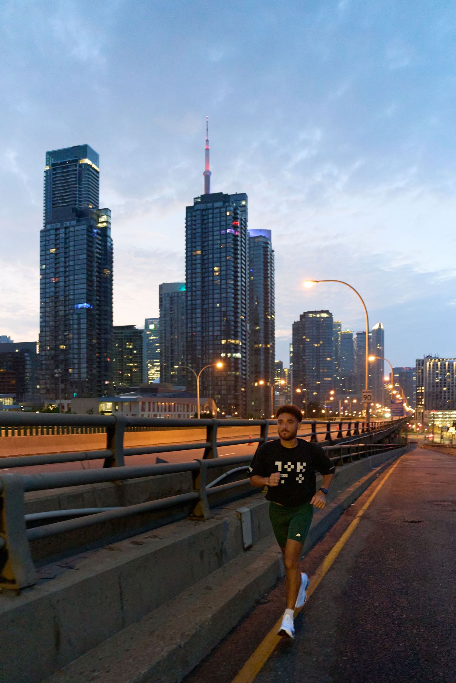 Three figures are positioned on a bridge, admiring the cityscape below.