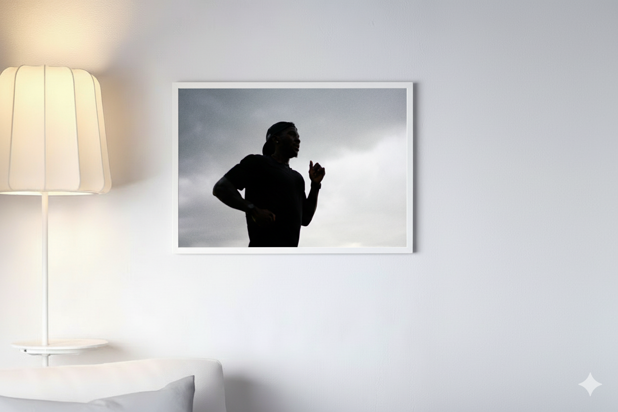 A dark silhouette of a runner positioned in front of a bright white wall, emphasizing the outline of his form.