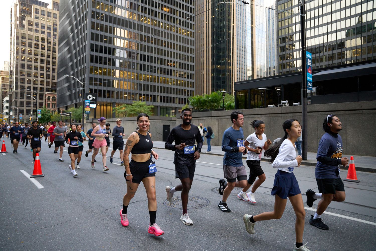 Diverse group of runners smiling and running through the city