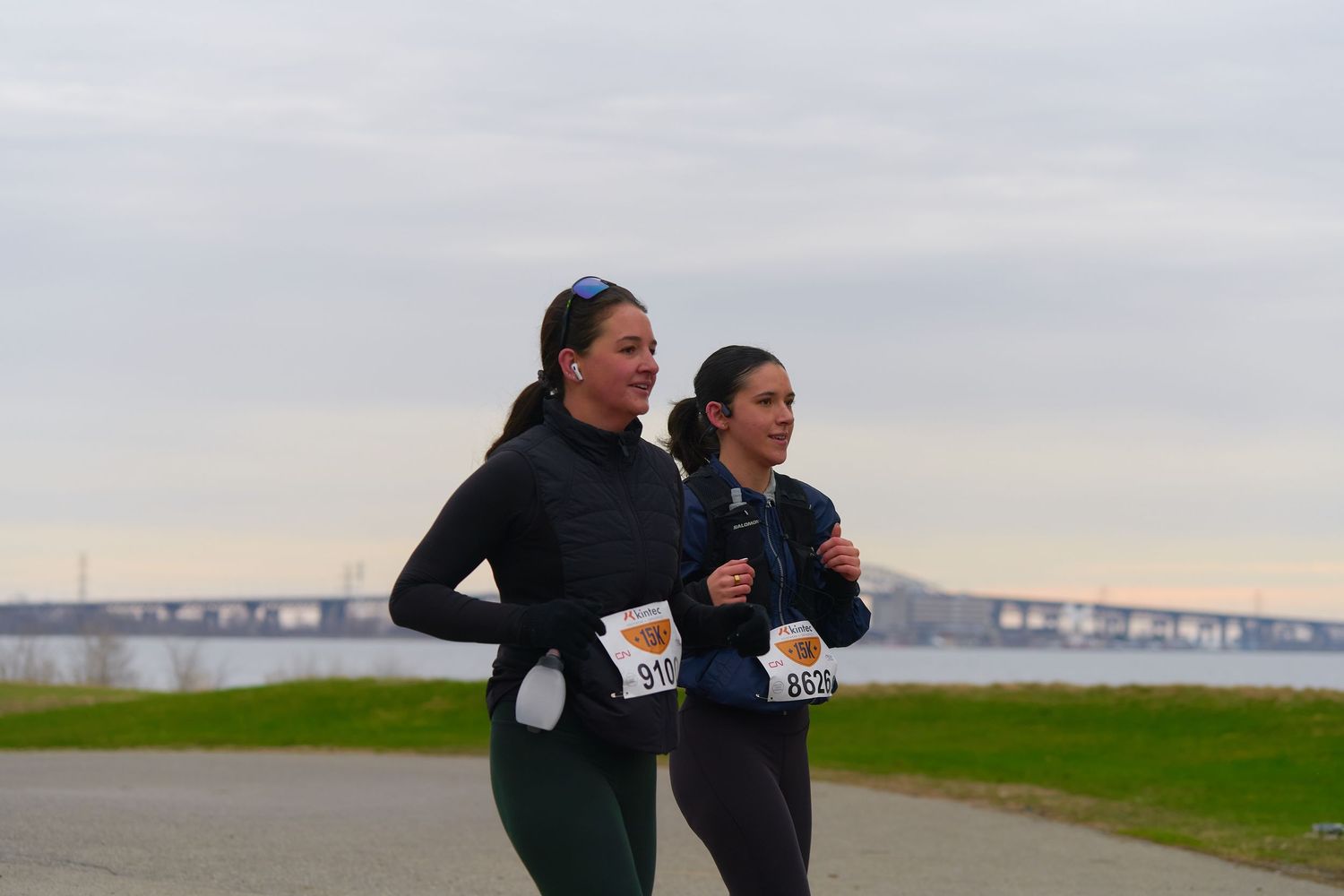 Two women running under a bridge, showcasing an active lifestyle in an urban environment.