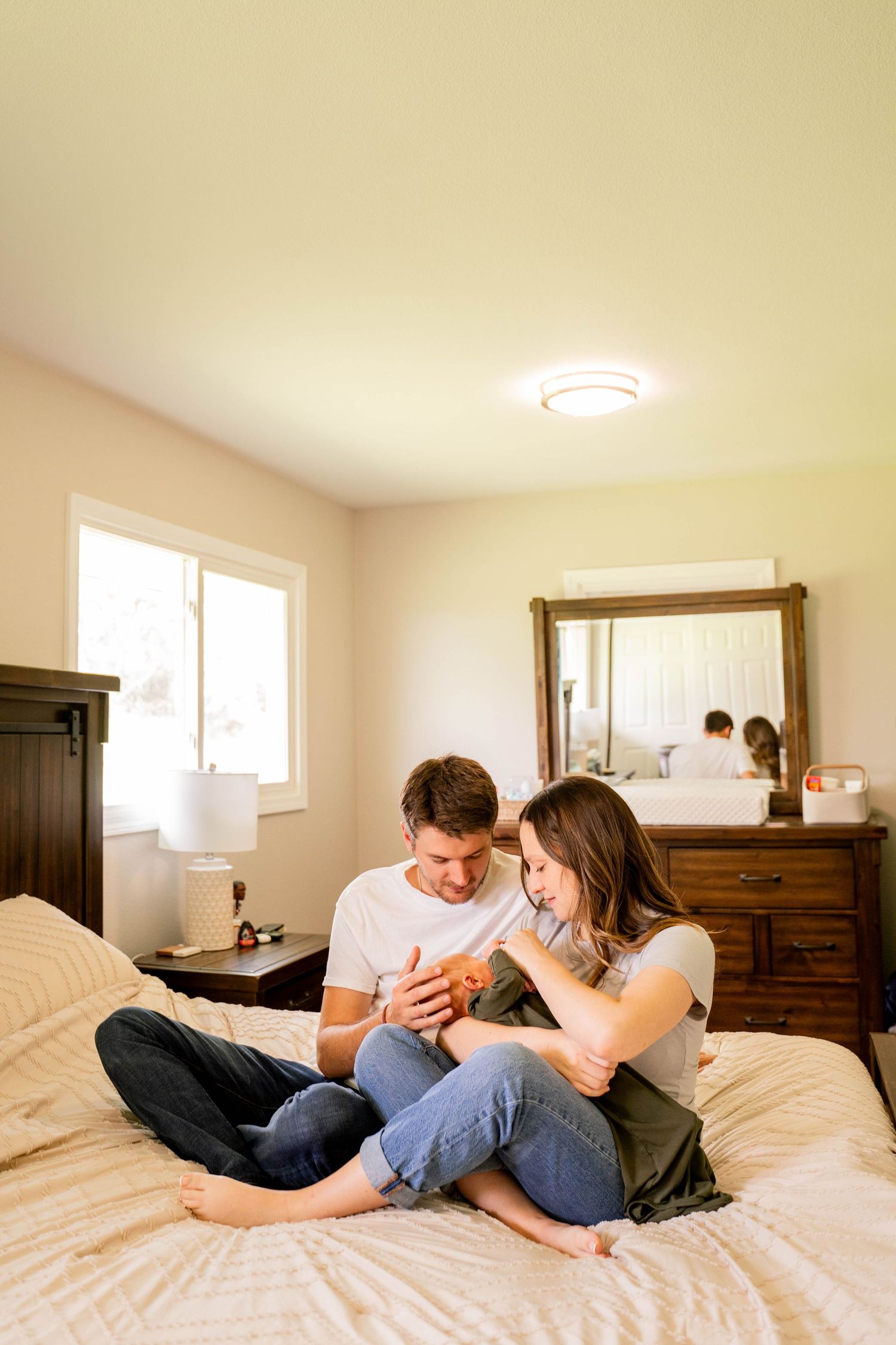 Intimate lifestyle photos of couple relaxing together on white bedding.