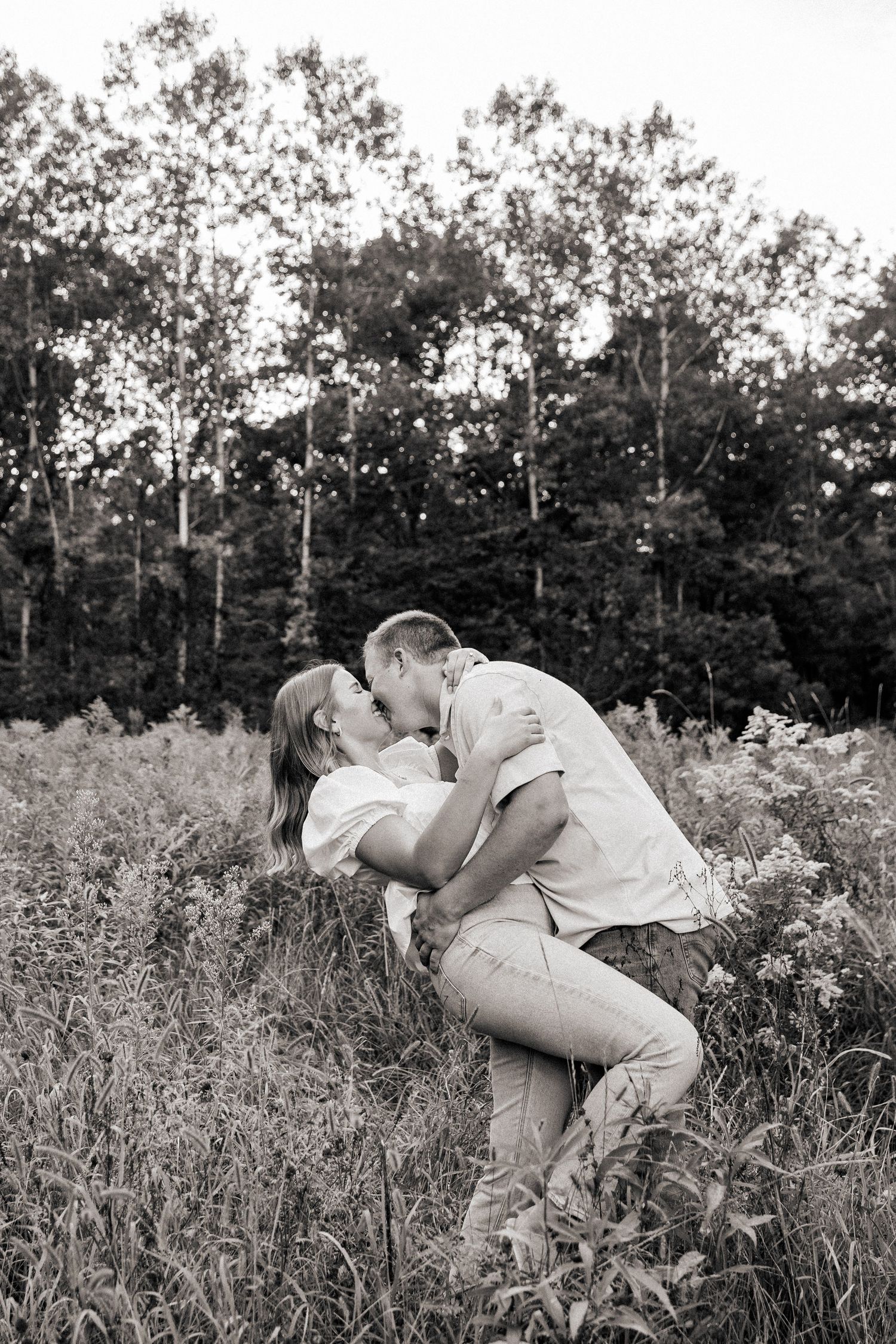 Black and white engagement photos in a wildflower field.