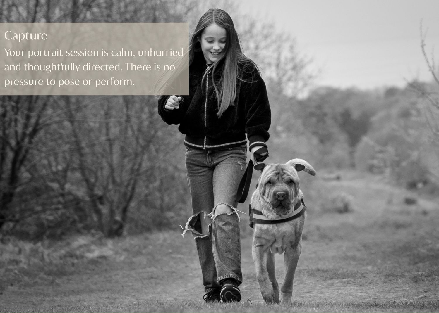A dog and person walking together on a misty forest path in black and white.