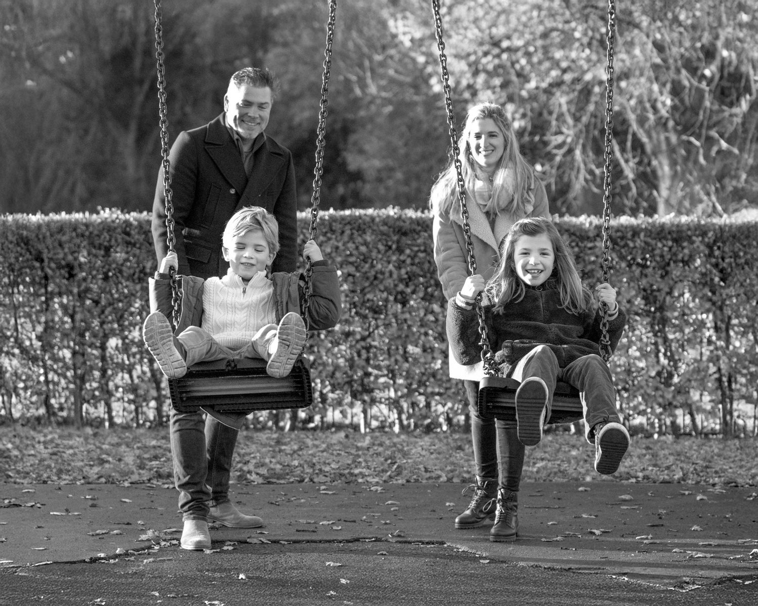A sequence of black and white photos showing children swinging on playground swings in an outdoor setting.