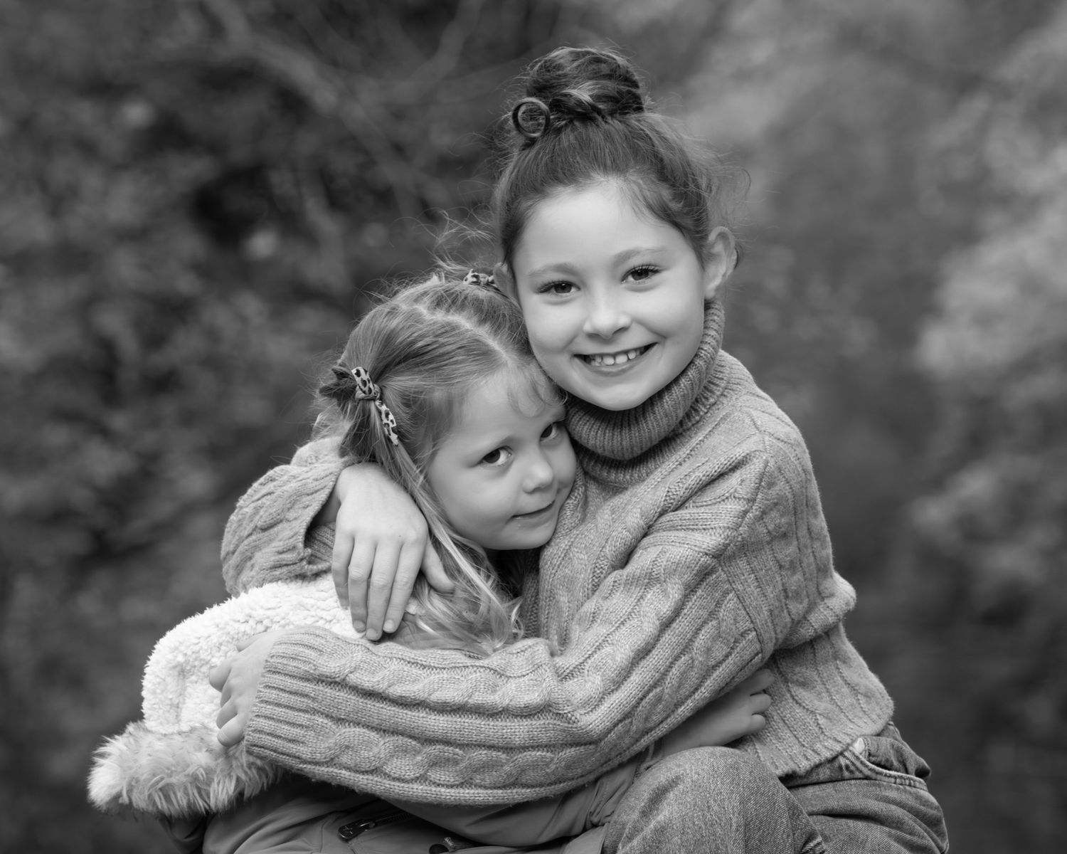 A heartwarming black and white photo series showing children embracing and hugging each other outdoors.