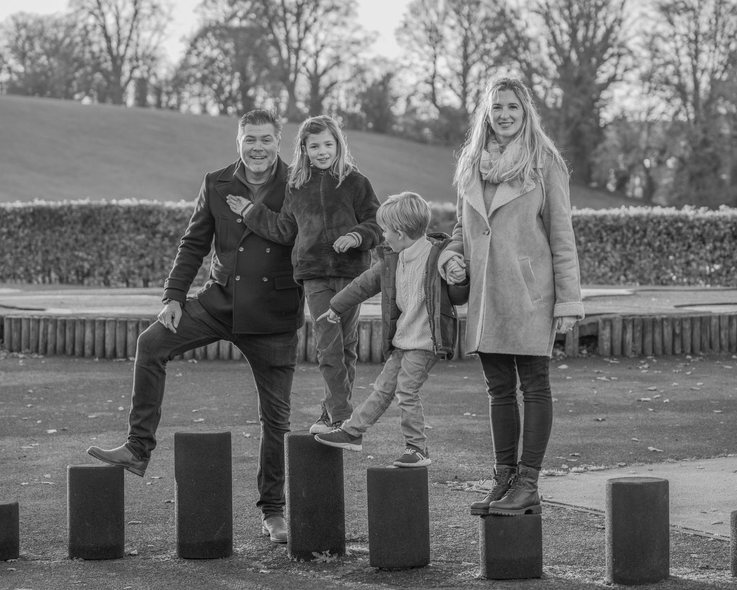 A sequence of black and white images showing people placing items on wooden posts in an outdoor setting.