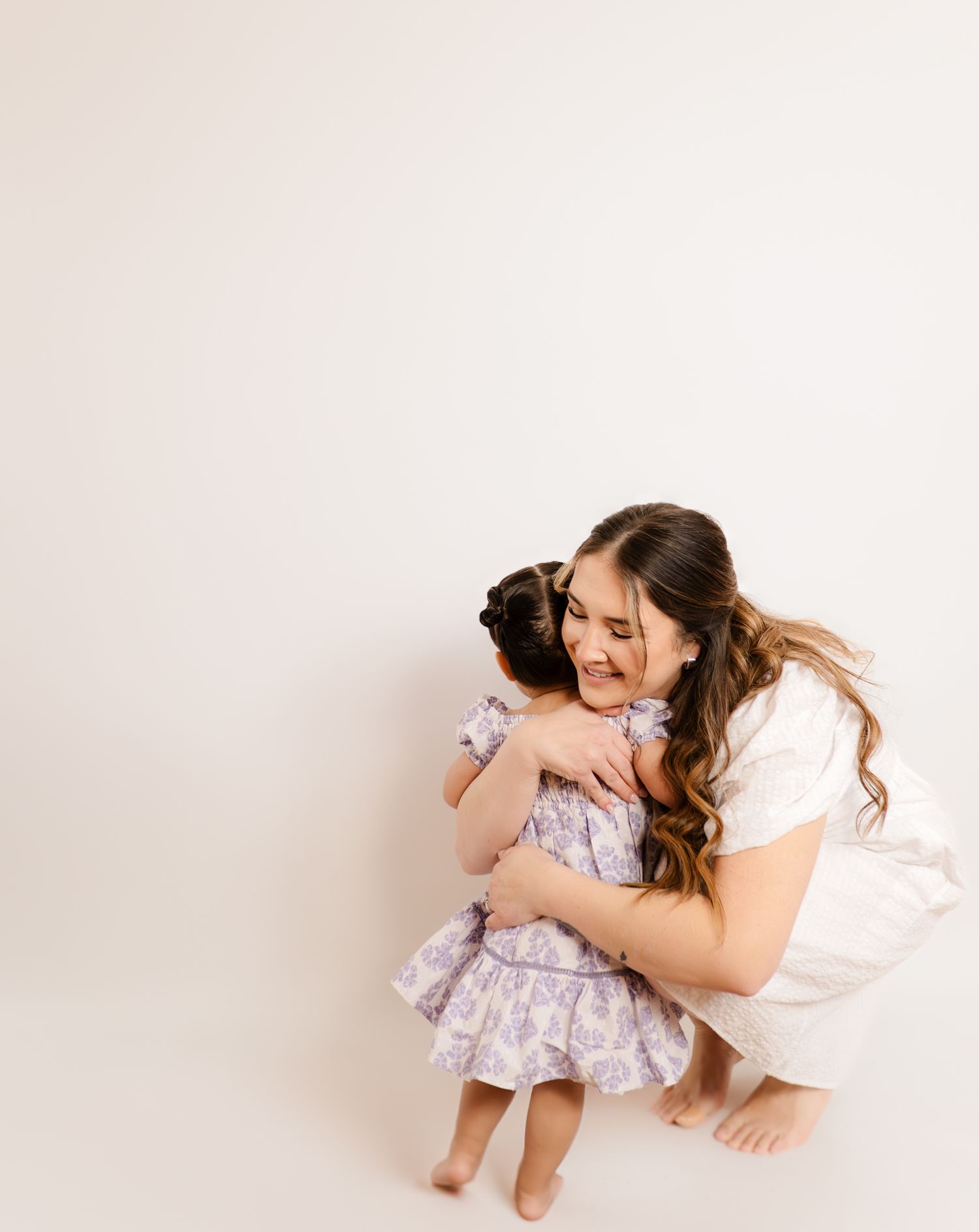 An intimate moment of embrace between two people wearing white and floral dresses.