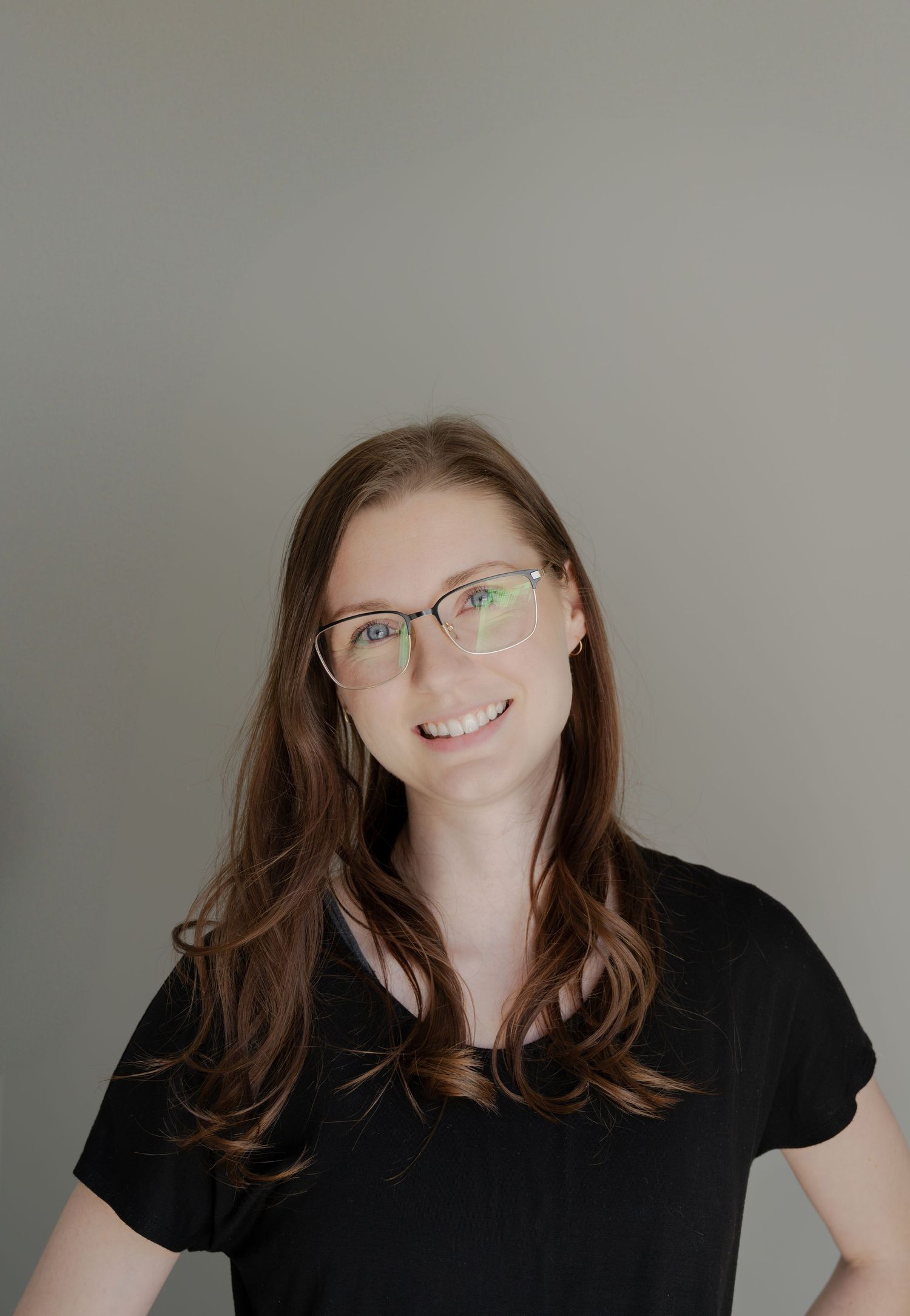 Portrait against neutral grey background in studio setting.
