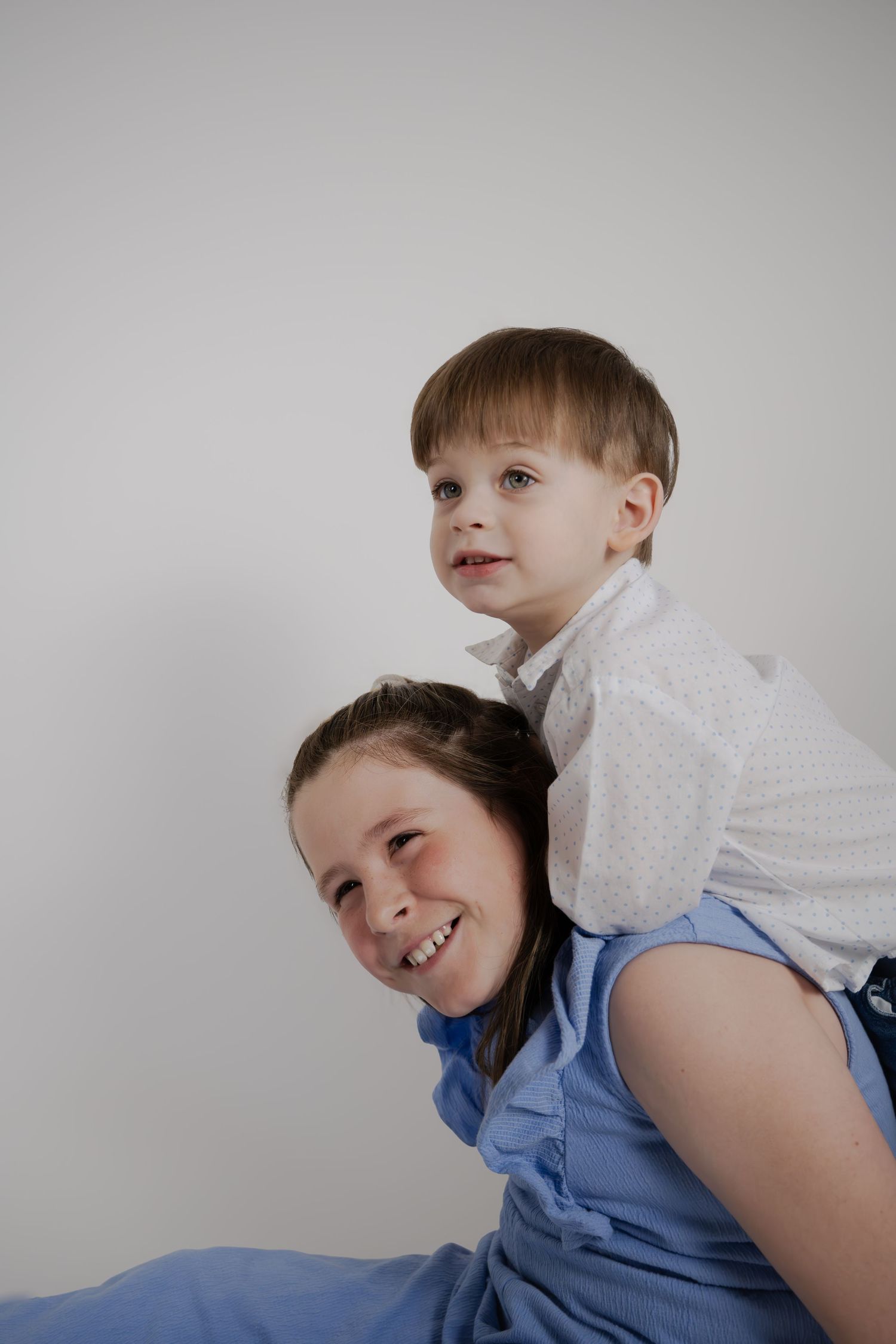 Playful shoulder ride portrait against light background showing joy and connection.